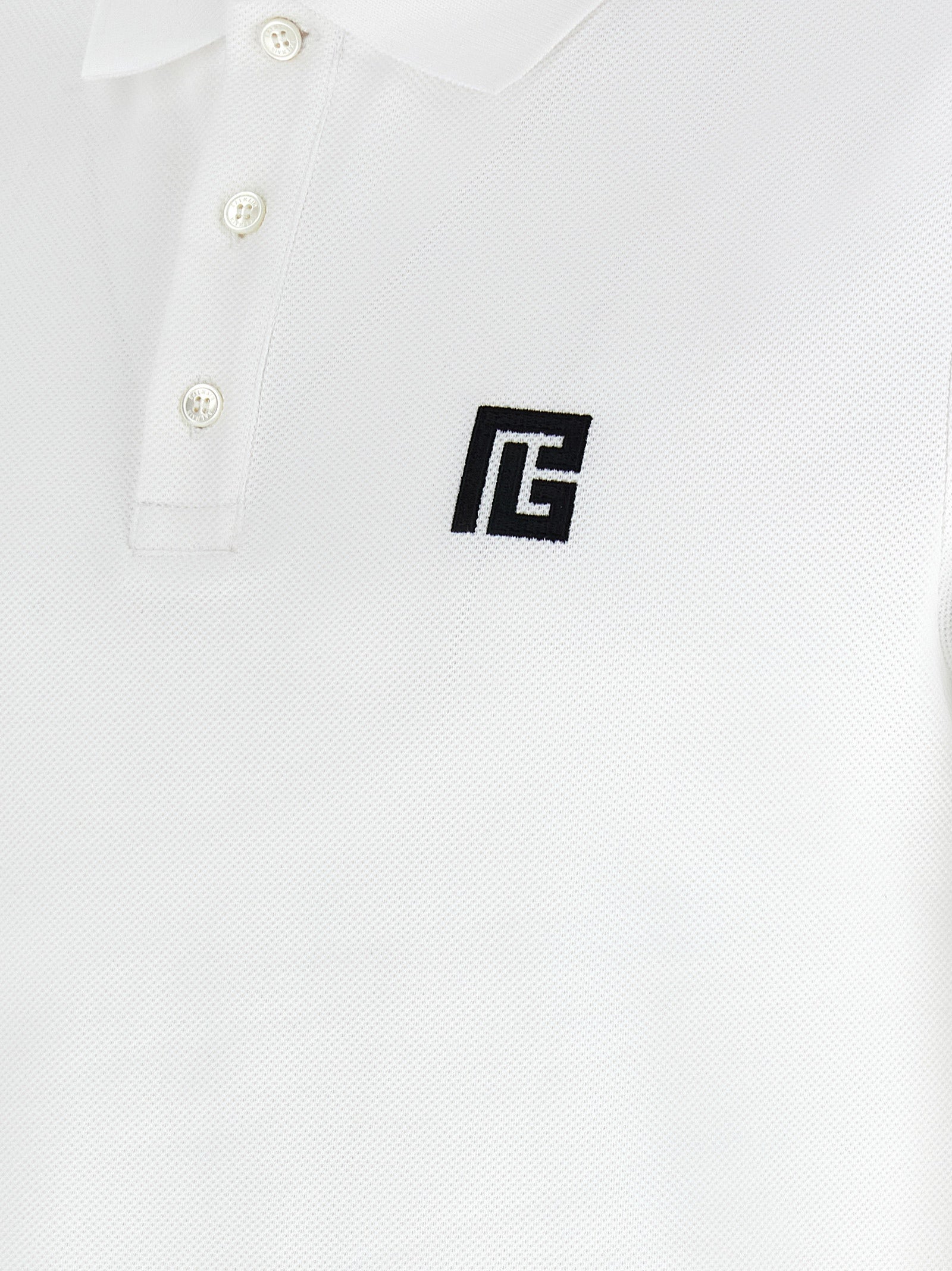 Chemise polo en coton bicolore Balmain, avec col et manches contrastantes, portée décontractée pour homme ou femme.