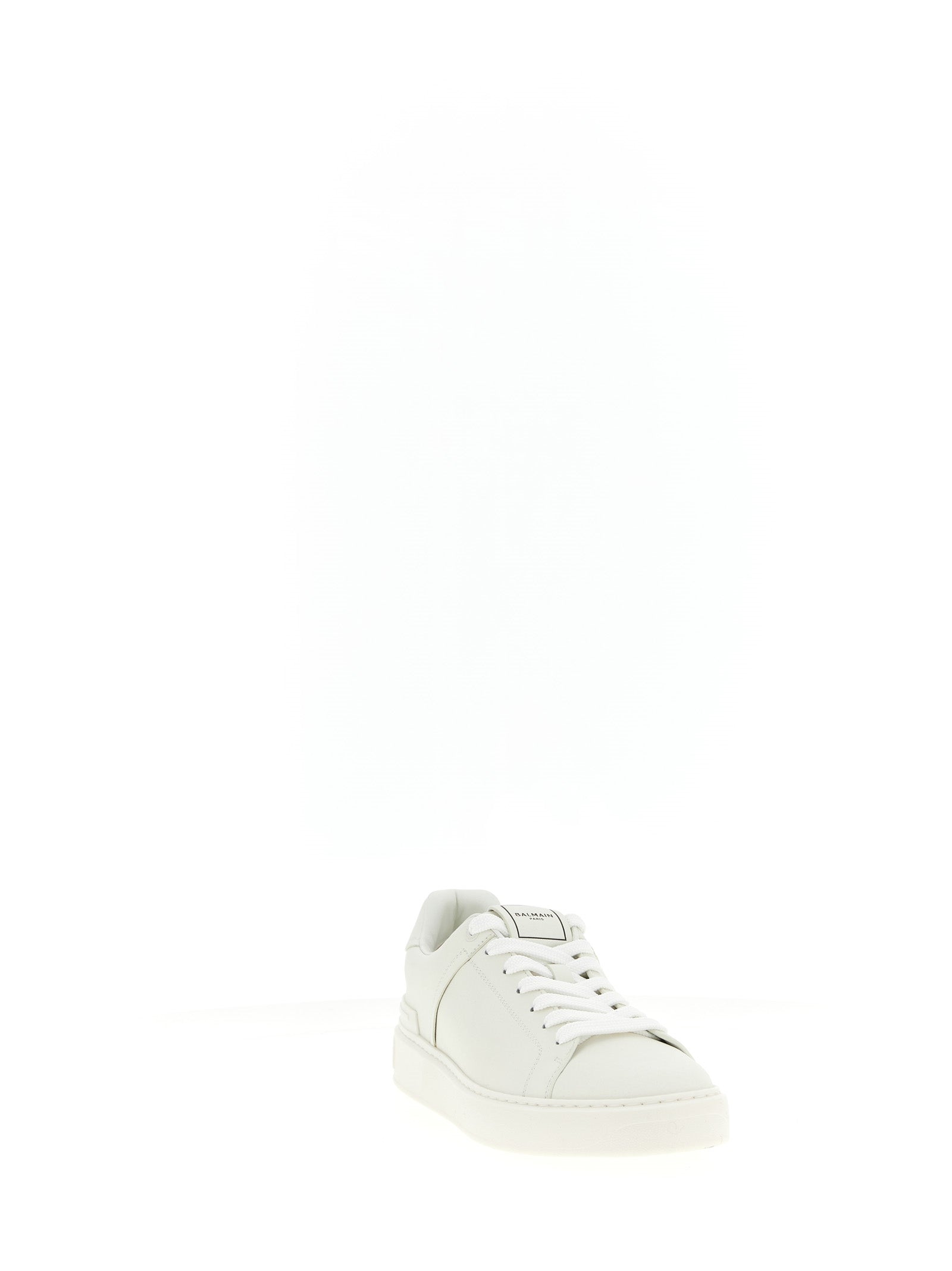 Sneakers blanches en cuir de veau Balmain avec design élégant et détails sophistiqués, vue de face sur fond neutre.