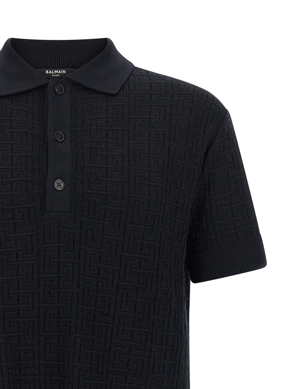Chemise polo en laine bleue Balmain, vue détaillée du tissu et du col sur fond neutre.