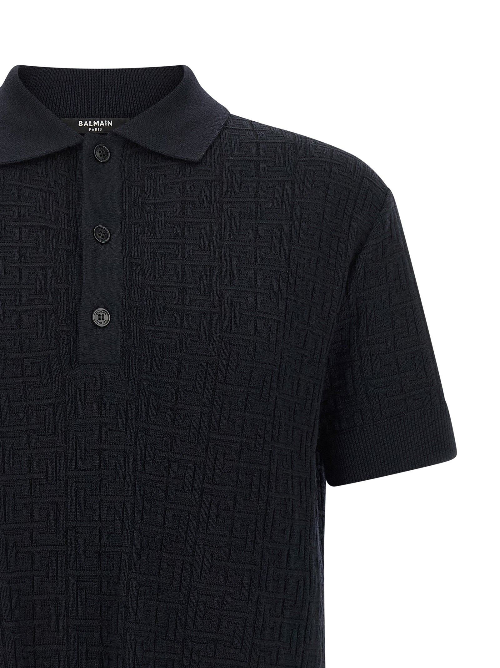 Chemise polo en laine bleue Balmain, vue détaillée du tissu et du col sur fond neutre.