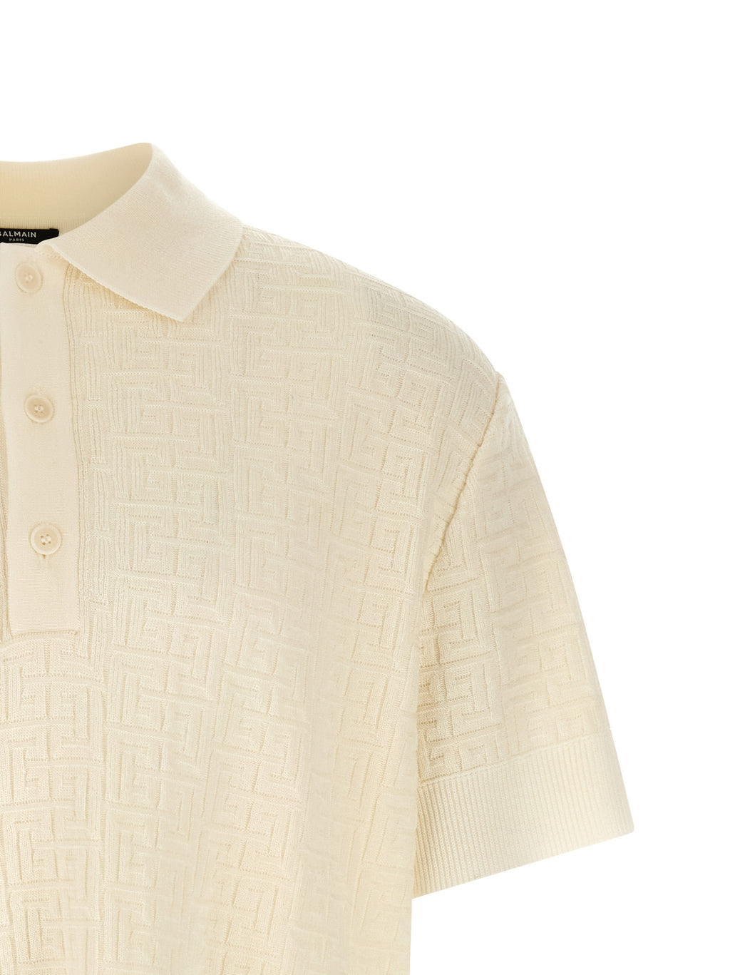 Chemise polo en laine blanche Balmain, vue de face, détails du col et des boutons, tissu doux et élégant.