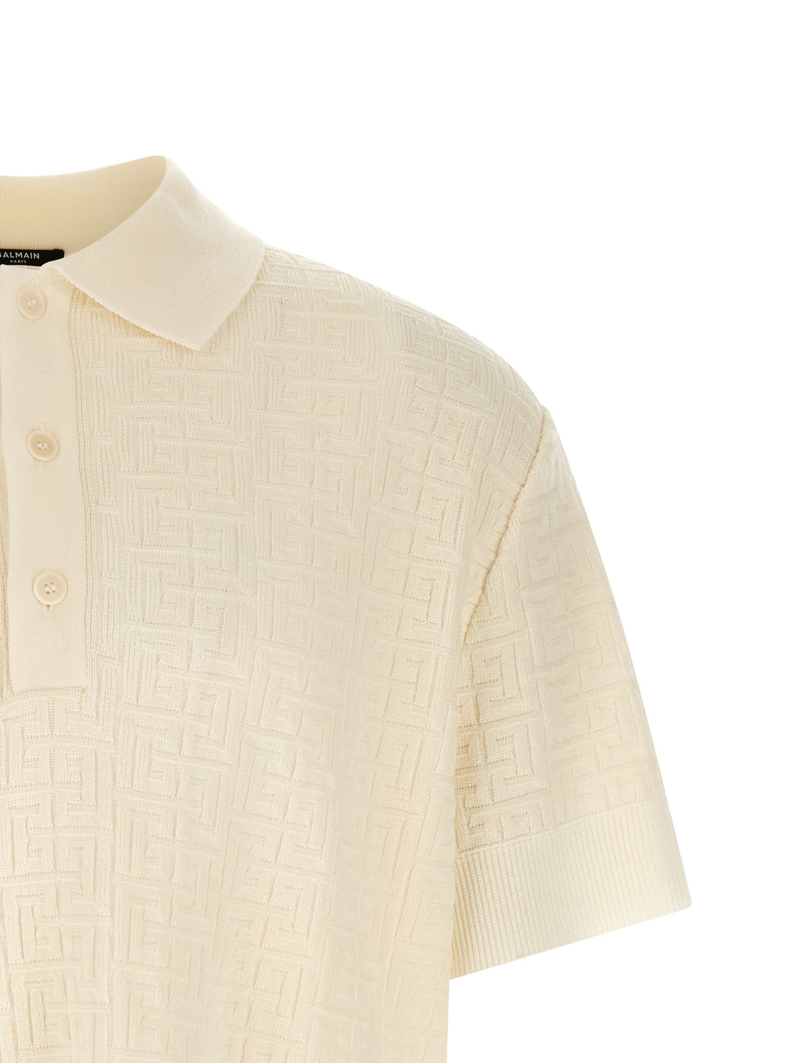 Chemise polo en laine blanche Balmain, vue de face, détails du col et des boutons, tissu doux et élégant.