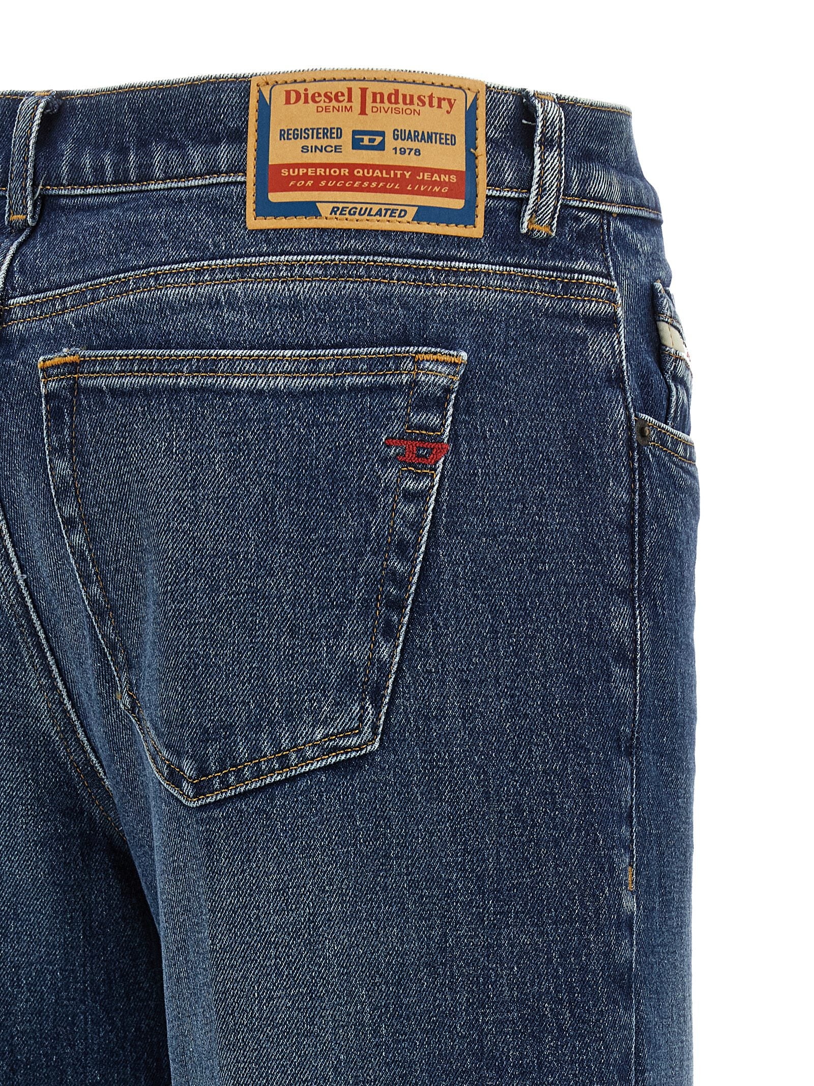 Jeans Diesel bleu en coton évasé, coupe flare, avec détails de couture visibles et taille haute élégante.