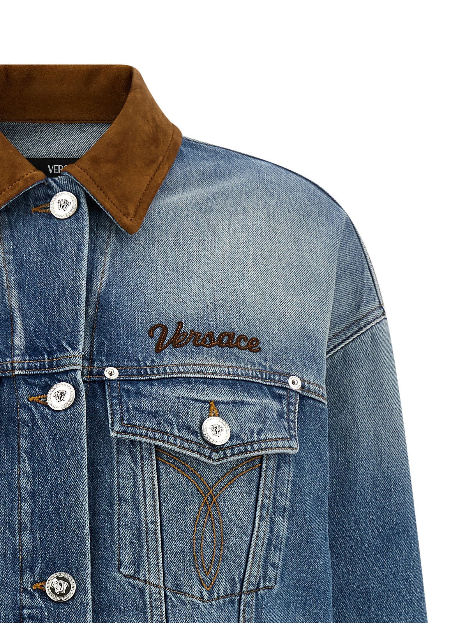 Veste en denim bleu en coton de la marque Versace, avec détails de style sophistiqué et logo visible.