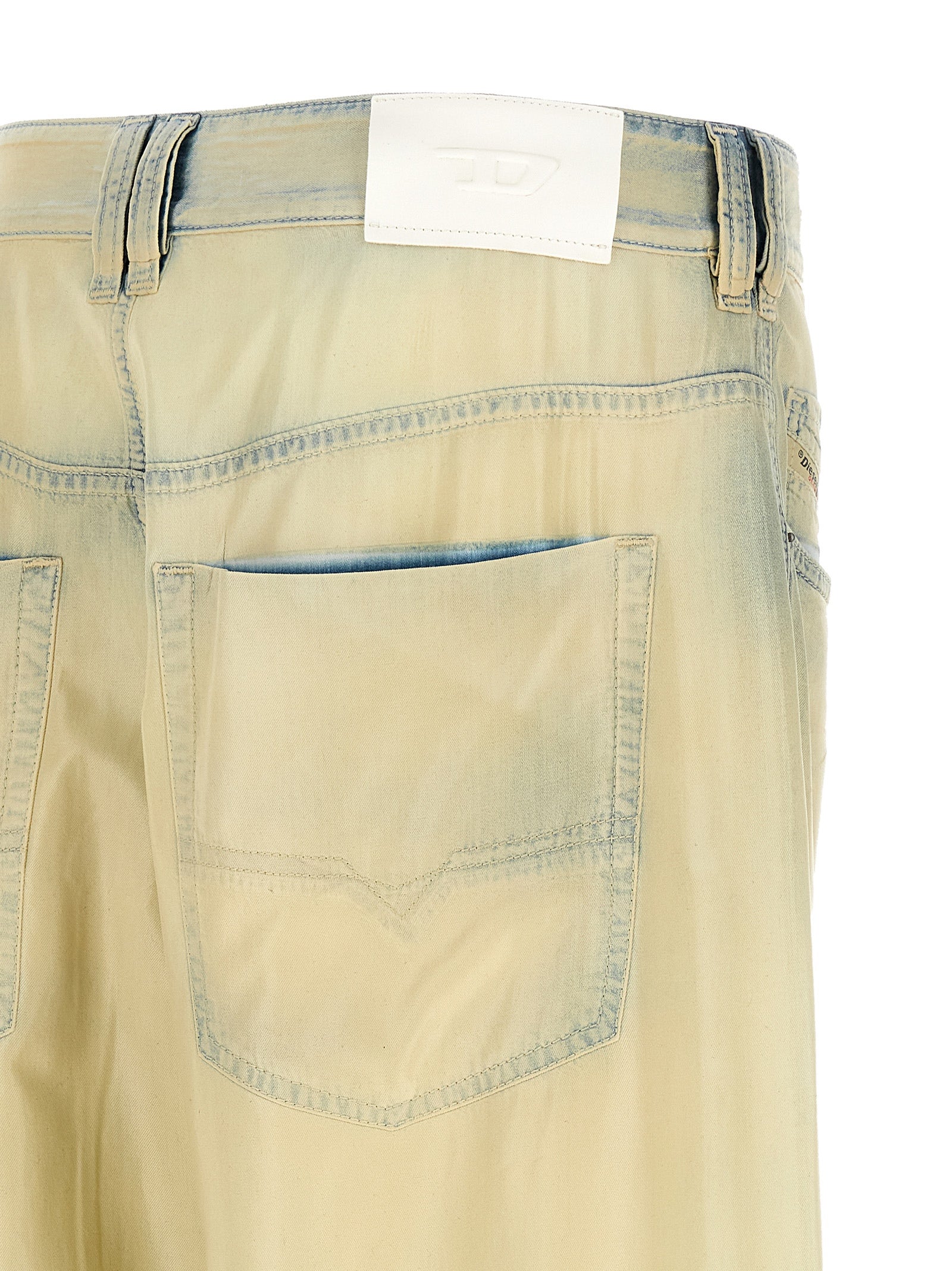 Jeans en denim beige Diesel Lyocell, coupe classique, pliés sur une surface en bois, visible détail du tissu et couture.
