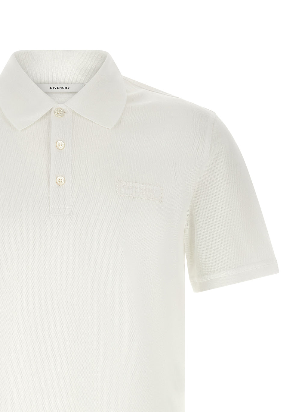 Chemise polo en coton blanc de Givenchy, avec col classique et logo discret, sur un fond neutre.