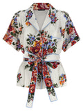 Chemise en soie blanche Dolce & Gabbana, élégante et fluide, avec col classique et manches longues, portée façon sophistiquée.