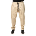 Pantalon jogger homme Dolce & Gabbana beige en coton skinny, ajusté et confortable, avec ceinture et poches visibles.
