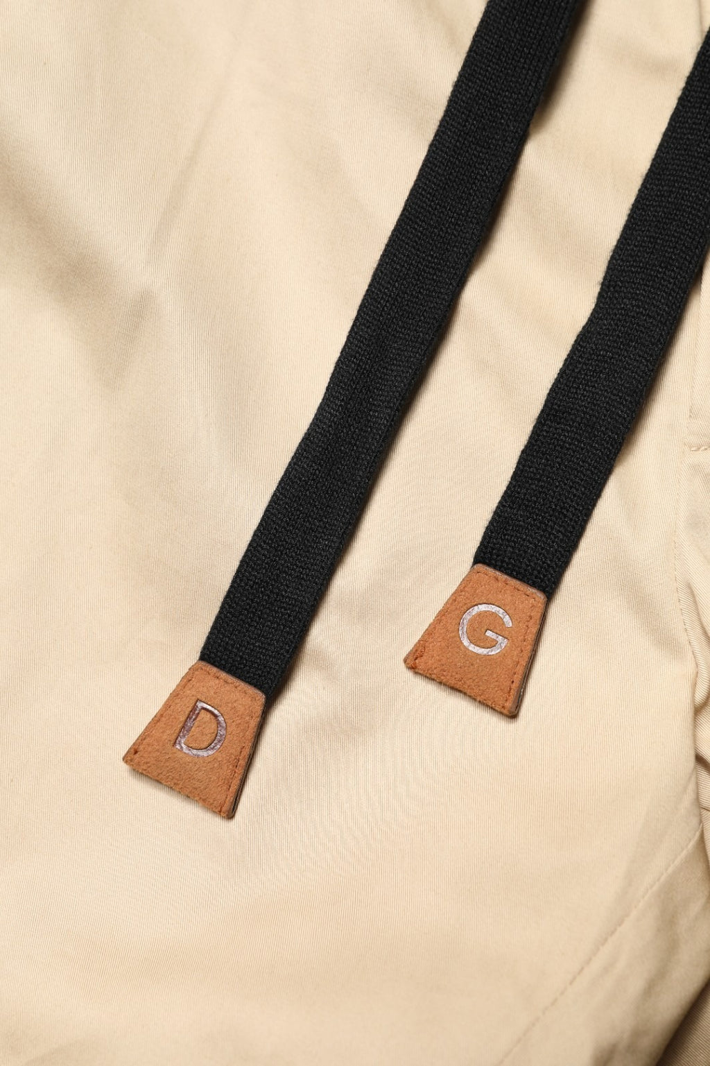 Pantalon jogger homme Dolce & Gabbana beige en coton, coupe skinny, avec détails modernes, sur mannequin.