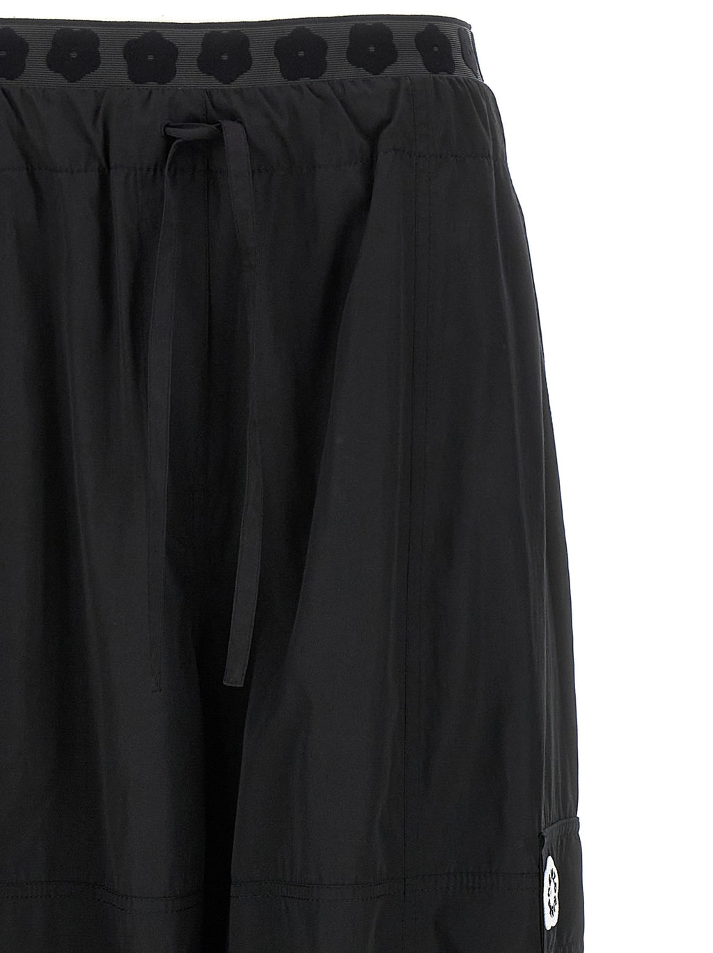 Pantalons cargo en polyester noir de la marque Kenzo, avec poches latérales et coupe décontractée visible sur l'image.