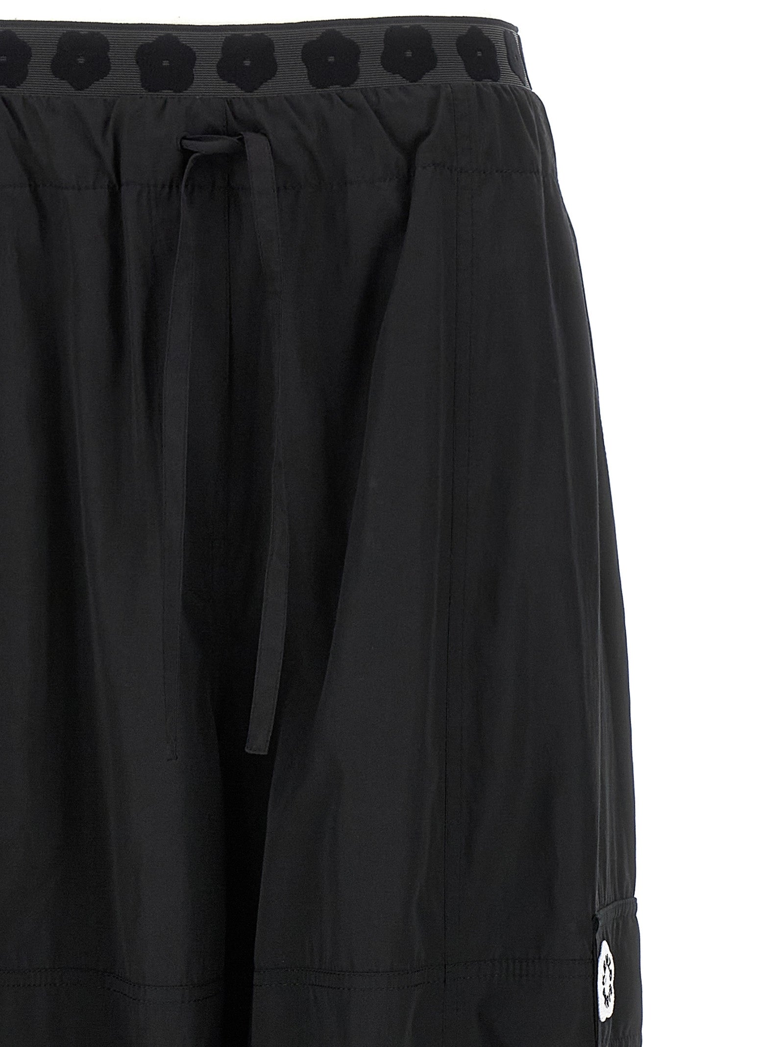 Pantalons cargo en polyester noir de la marque Kenzo, avec poches latérales et coupe décontractée visible sur l'image.