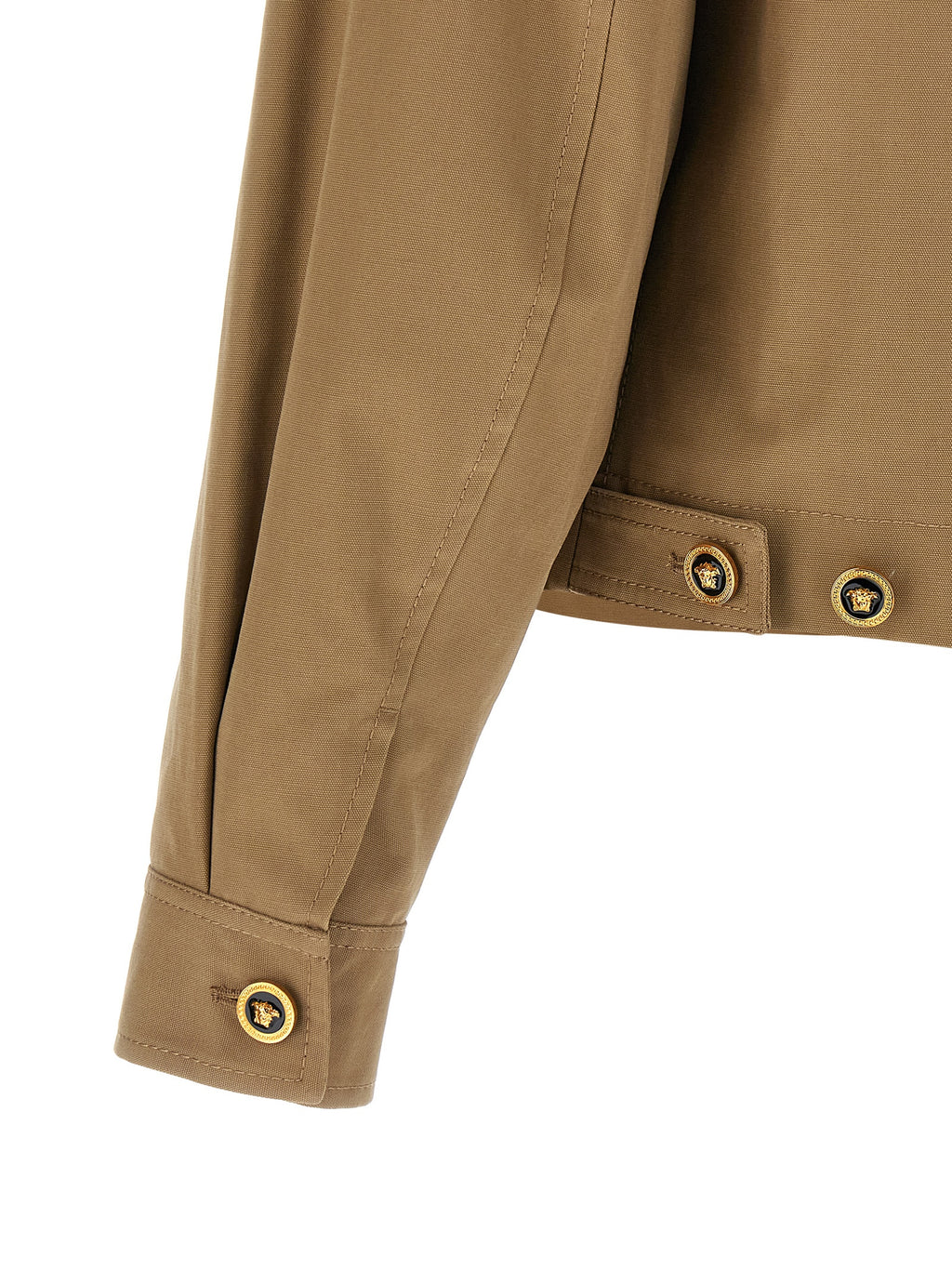 Veste en coton beige de la marque Versace, style élégant avec logo distinctif visible sur la veste.