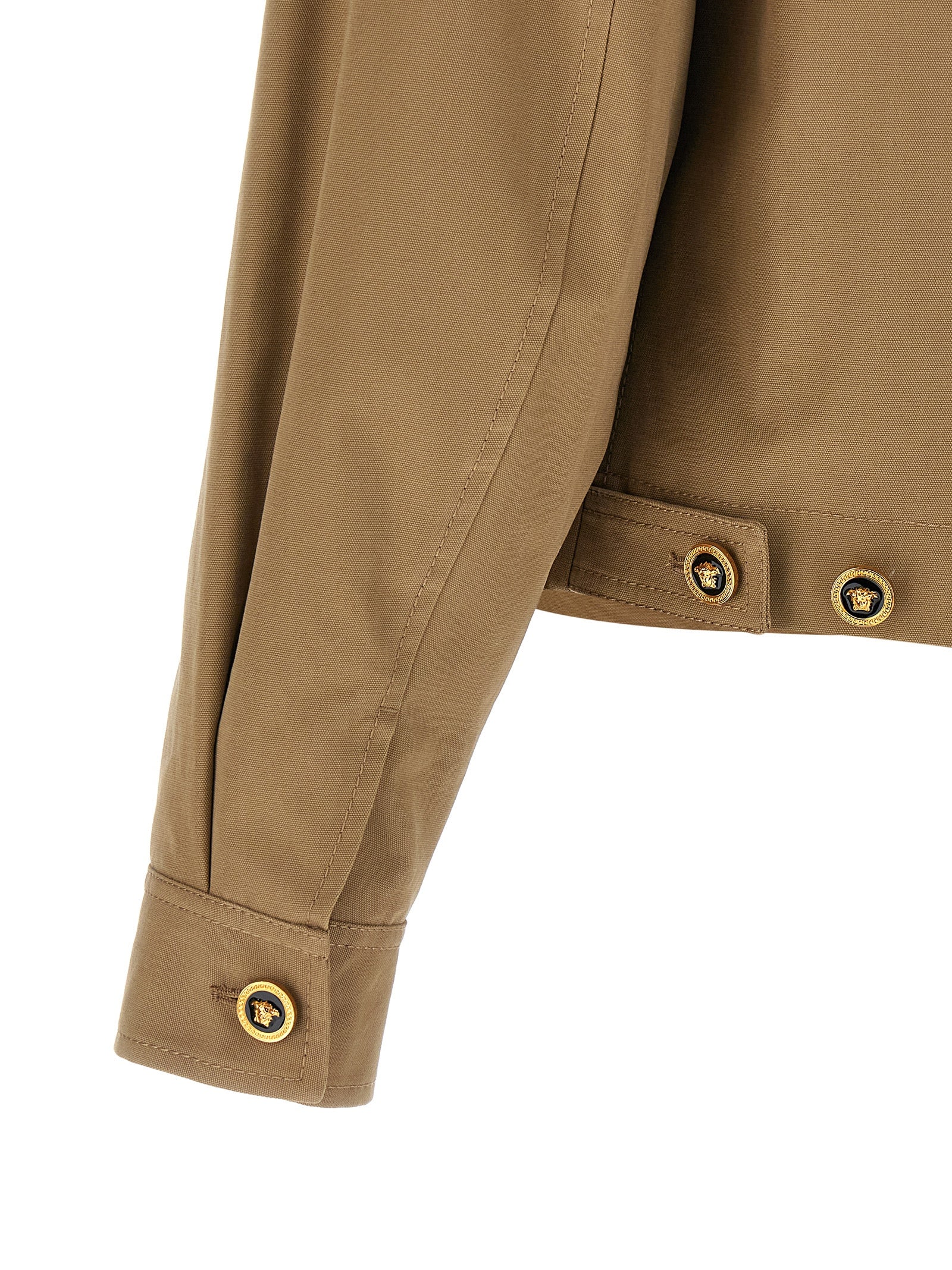 Veste en coton beige de la marque Versace, style élégant avec logo distinctif visible sur la veste.