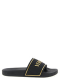 Sandales noires en polyurethane de la marque Versace, avec logo distinctif sur la bride.