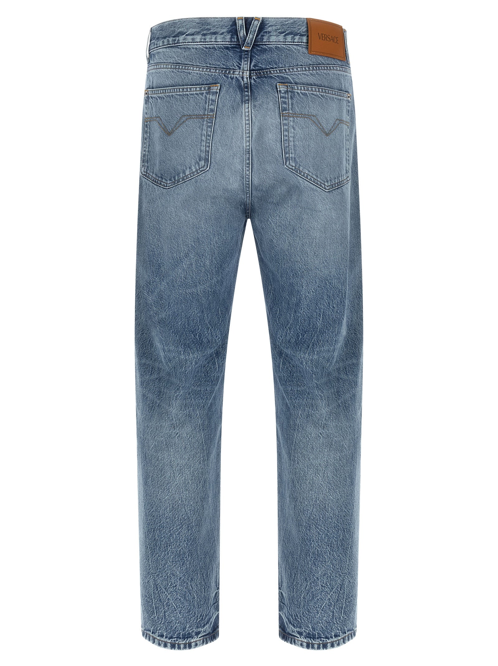 Jeans droits en coton bleu de la marque Versace, visible avec détails de coupe et couture.