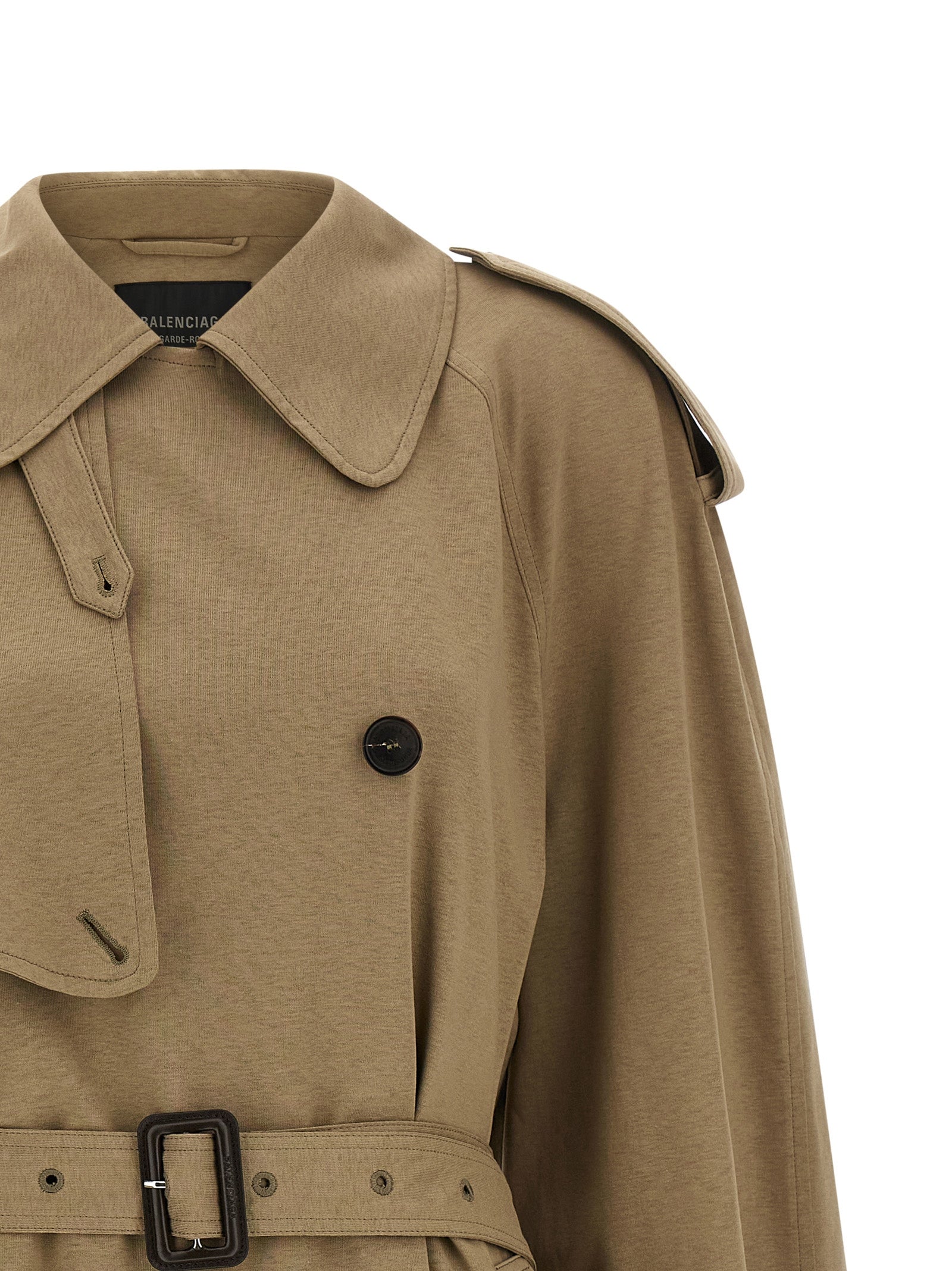 Manteau beige en coton de la marque Balenciaga, avec coupe élégante et détails modernes, porté sur un mannequin.
