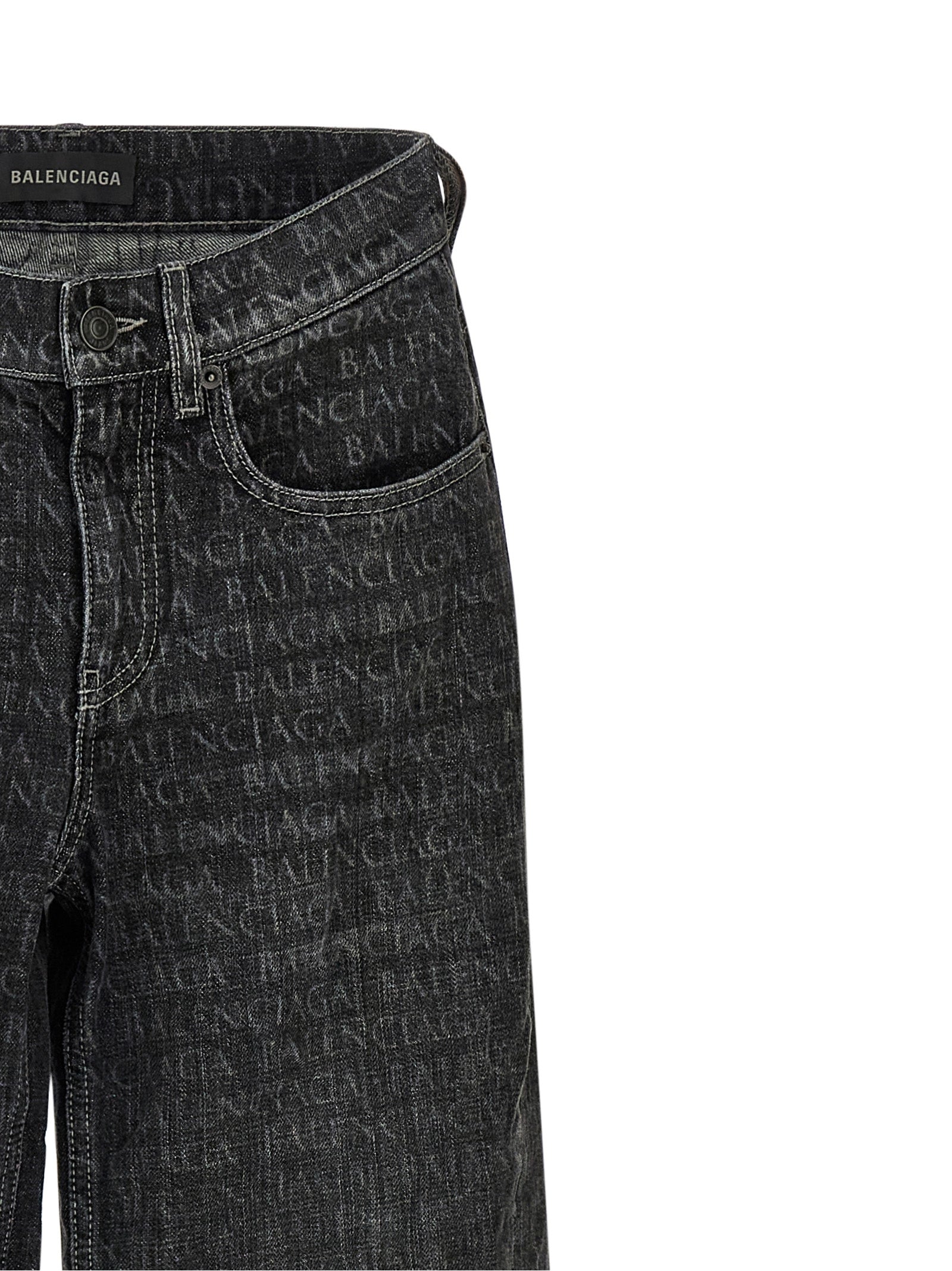 Jeans évasés en coton noir de la marque Balenciaga, avec coupe tendance et détails modernes, visibles en gros plan.