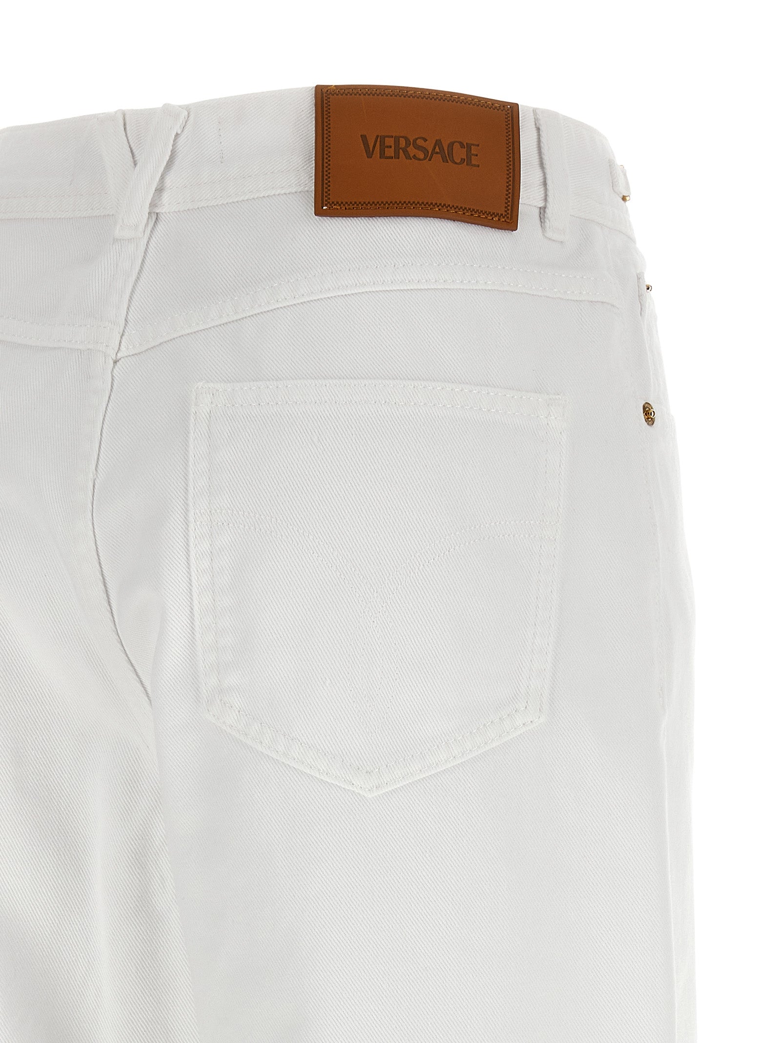 Jeans droits en coton blanc de la marque Versace, visible avec une coupe classique et un design épuré.