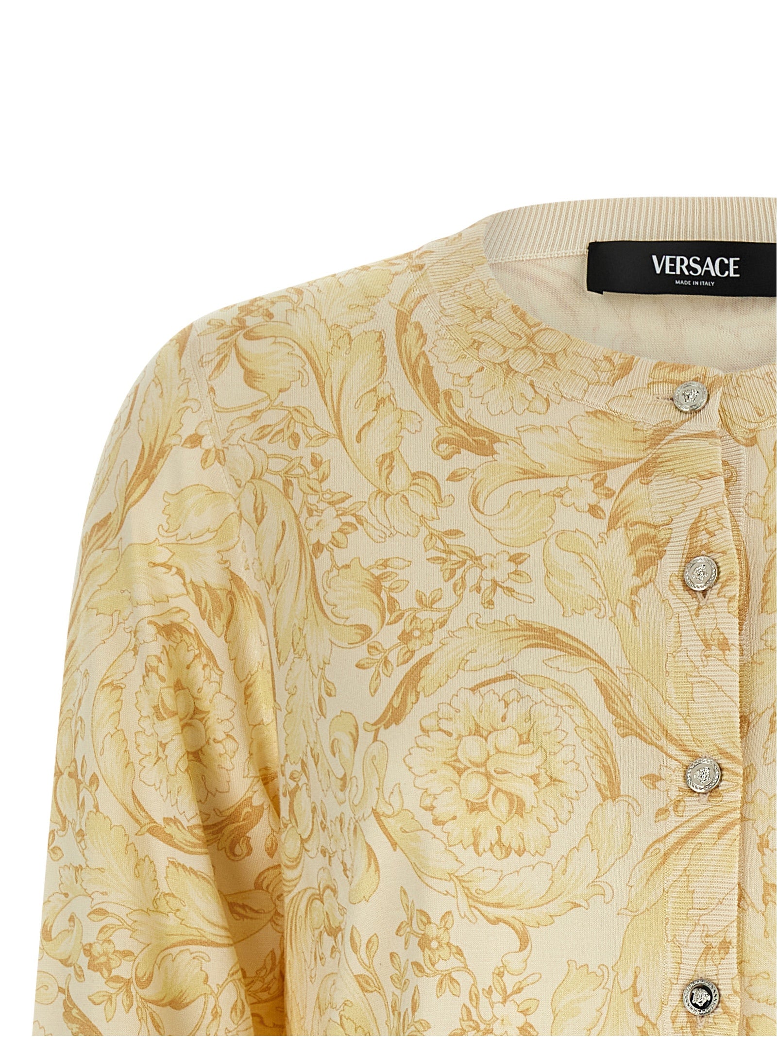 Cardigan en soie bicolore Versace porté, détails élégants et couture de luxe, tissu doux et finition soignée.