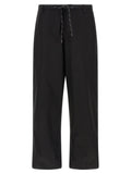 Pantalon chino en coton noir de Balenciaga, coupe classique, détails élégants, porté sur mannequin.