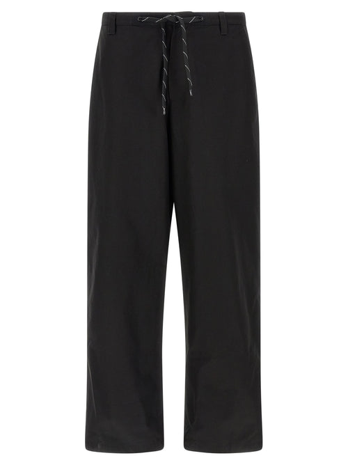 Pantalon chino en coton noir de Balenciaga, coupe classique, détails élégants, porté sur mannequin.