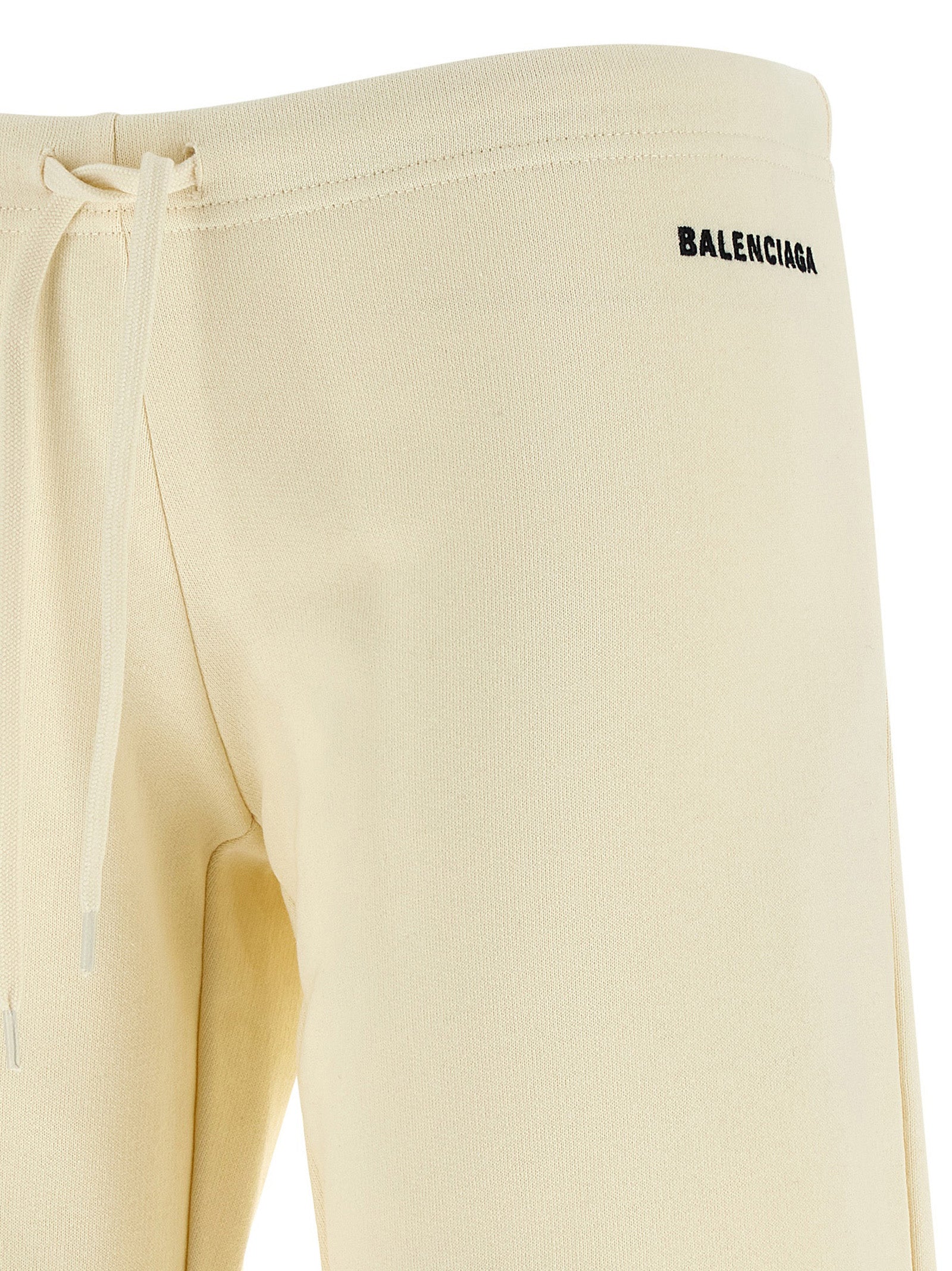 Pantalons évasés en coton blanc de Balenciaga, vue de face, détails de coupe flatteuse et texture douce visible.