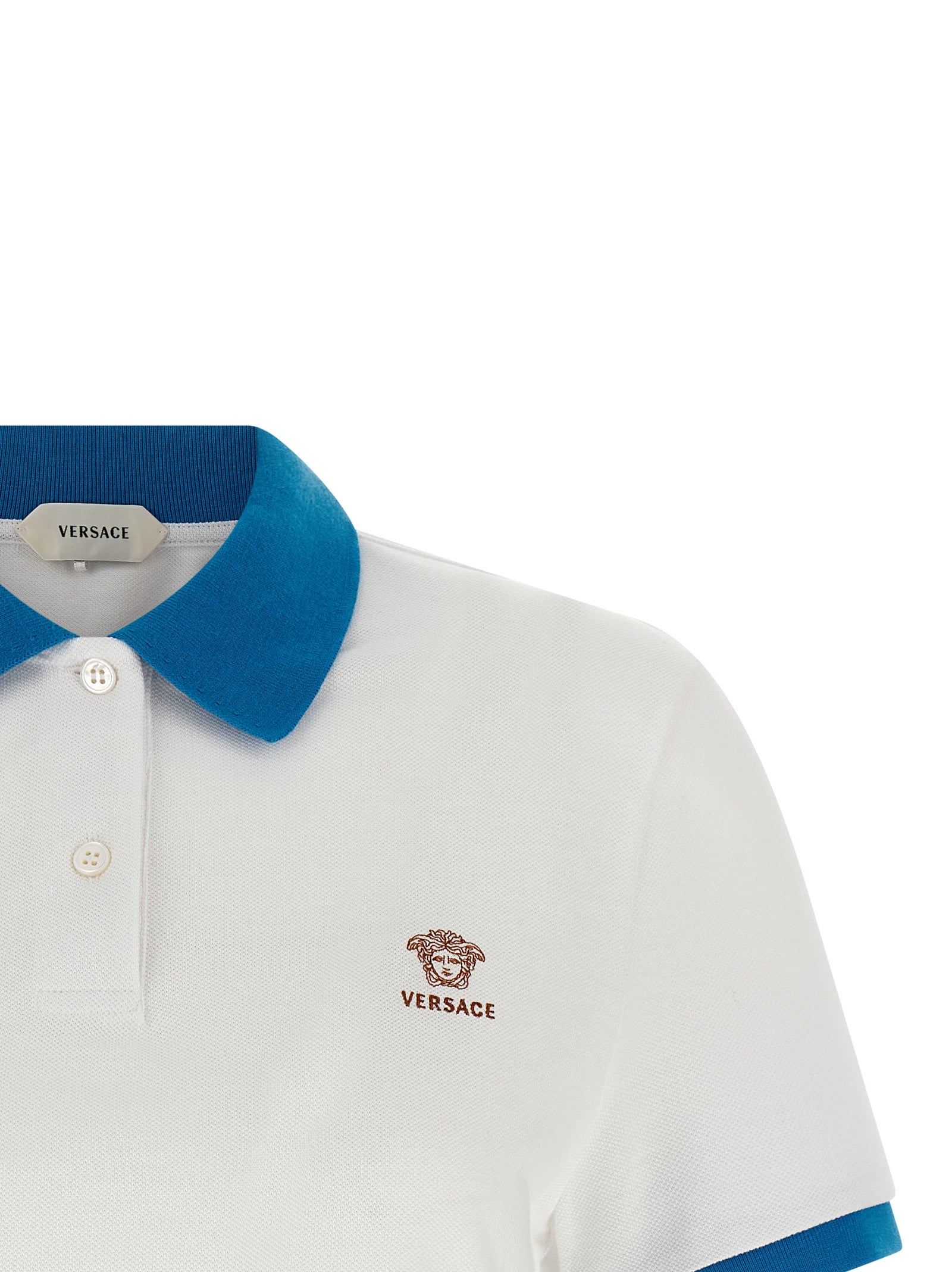 Chemise polo en coton bleu de la marque Versace, avec logo et design élégant visible sur la chemise.