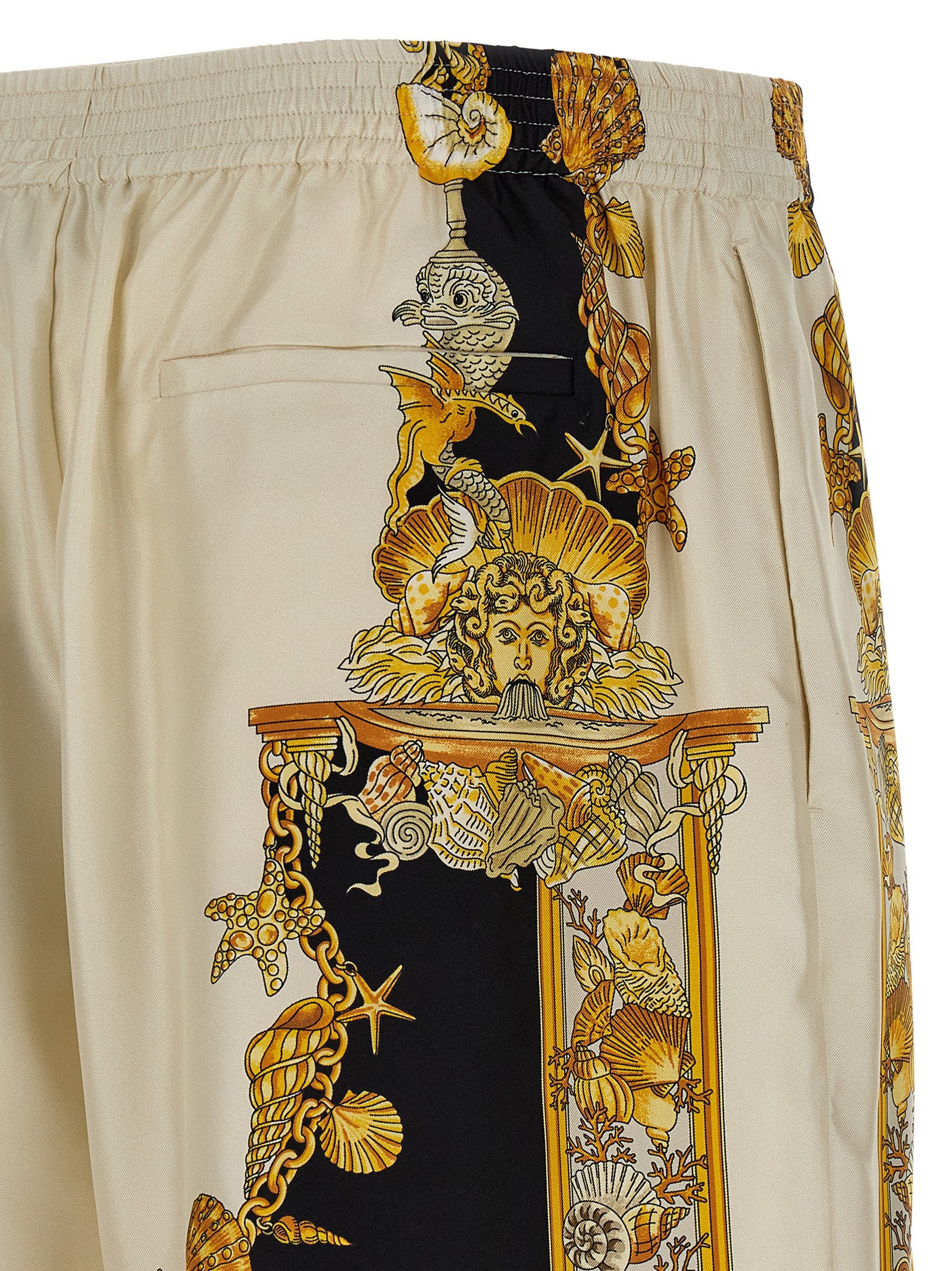 Shorts en soie multicolores de style bermuda de la marque Versace, avec motif élégant et tissu luxueux visible.