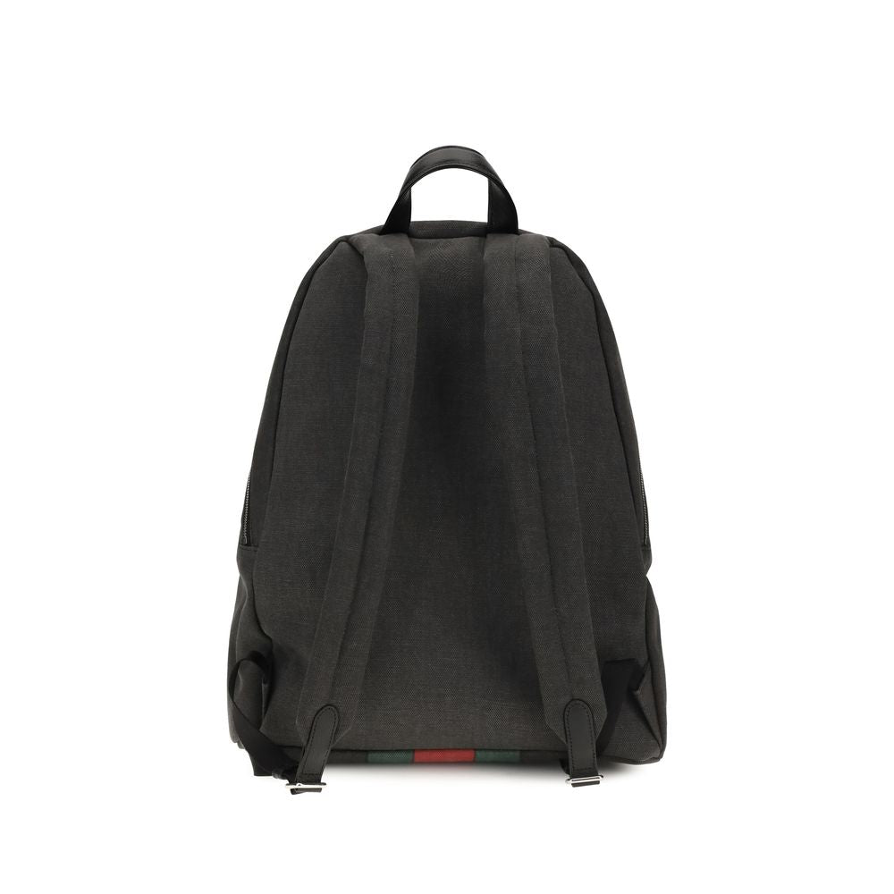 Sac à dos en tissu noir Gucci, mode urbaine avec logo Gucci, vue de face montrant les bretelles et le design élégant.