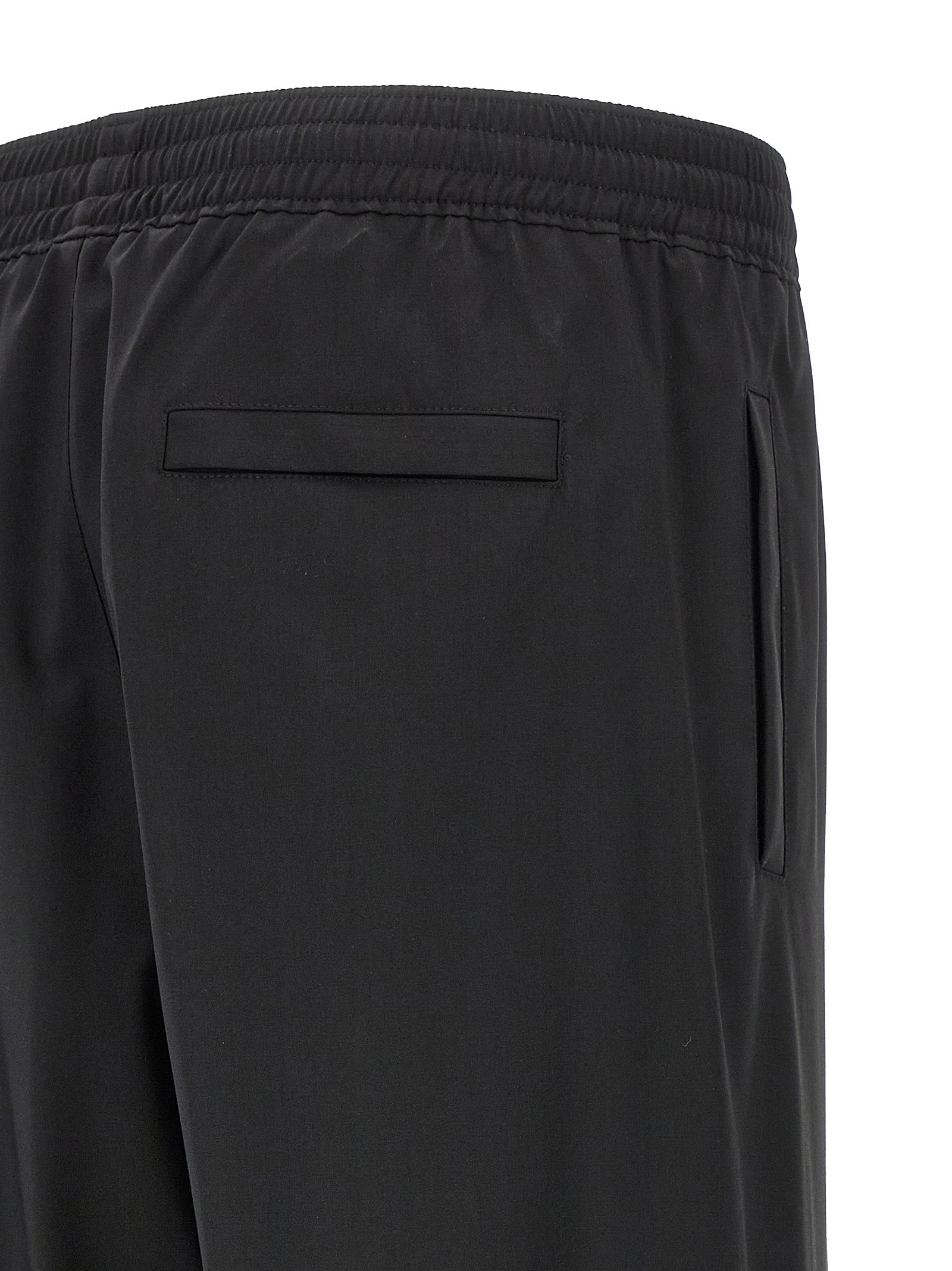 Pantalons décontractés en laine vierge noire de Givenchy, coupe élégante et style moderne, visibles sur l'image.