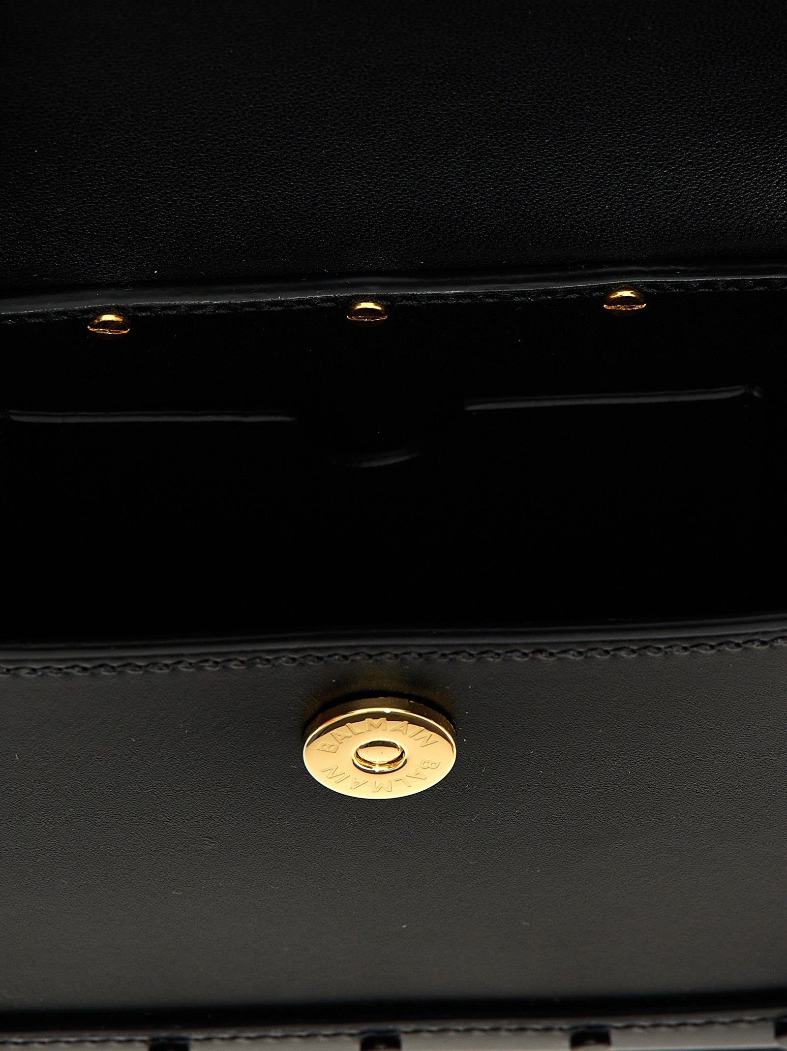 Sac à main en veau noir Balmain, élégant et sophistiqué, avec détails en métal et finition raffinée.