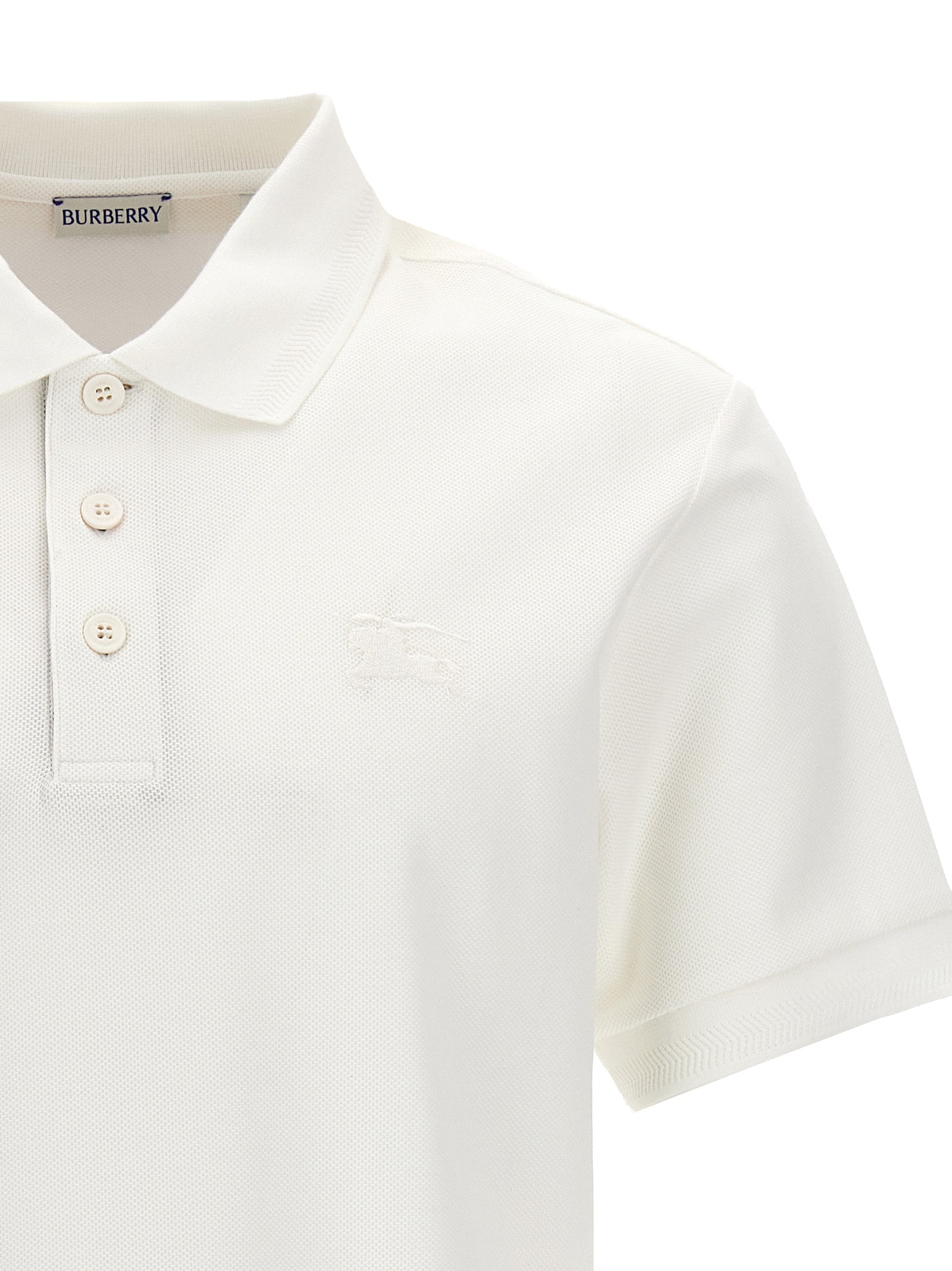 Chemise polo blanche en coton de la marque Burberry, avec col classique et logo emblématique visible.