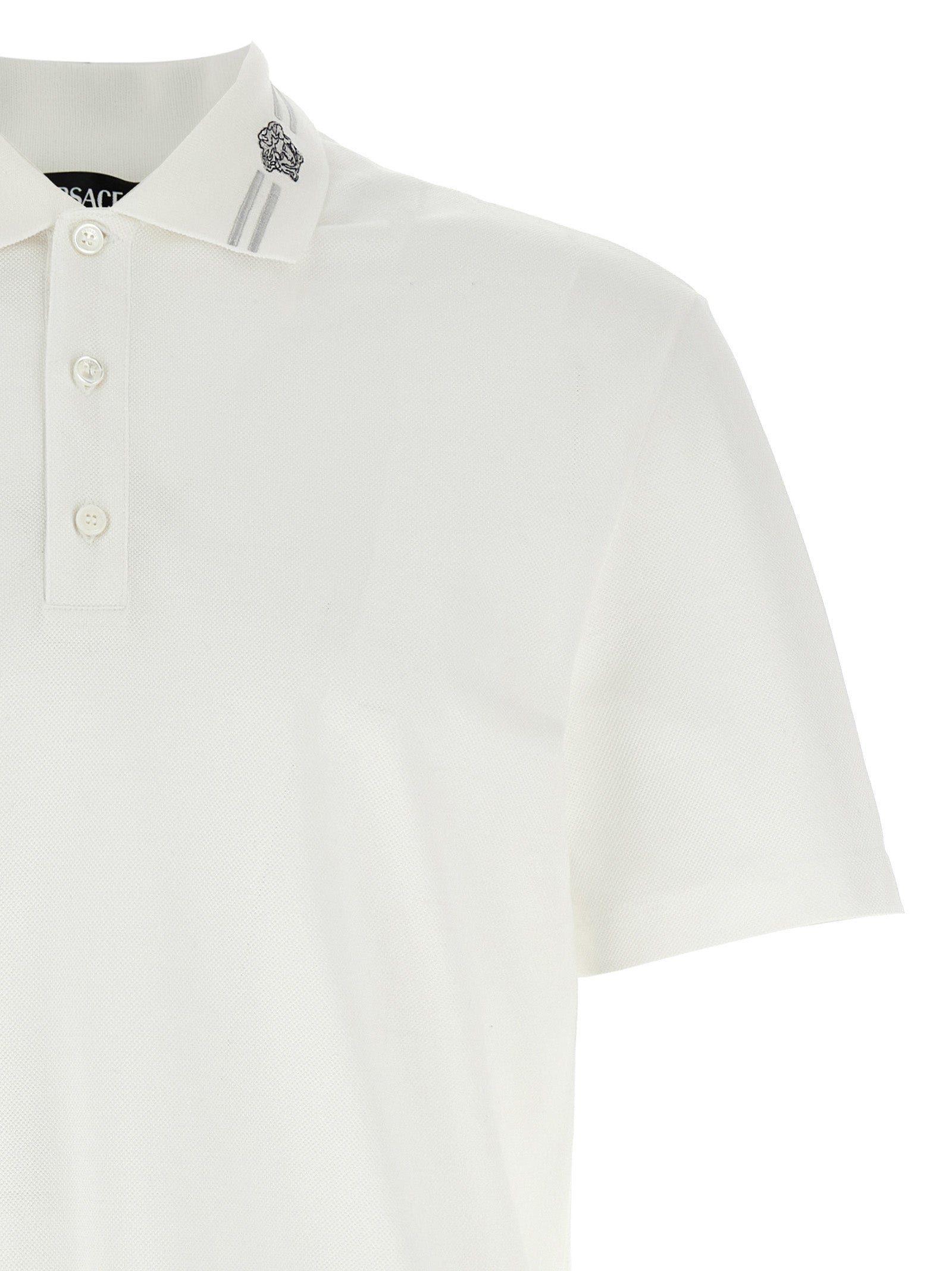 Chemise polo blanche en coton de la marque Versace, avec logo distinctif sur la poitrine et col classique.