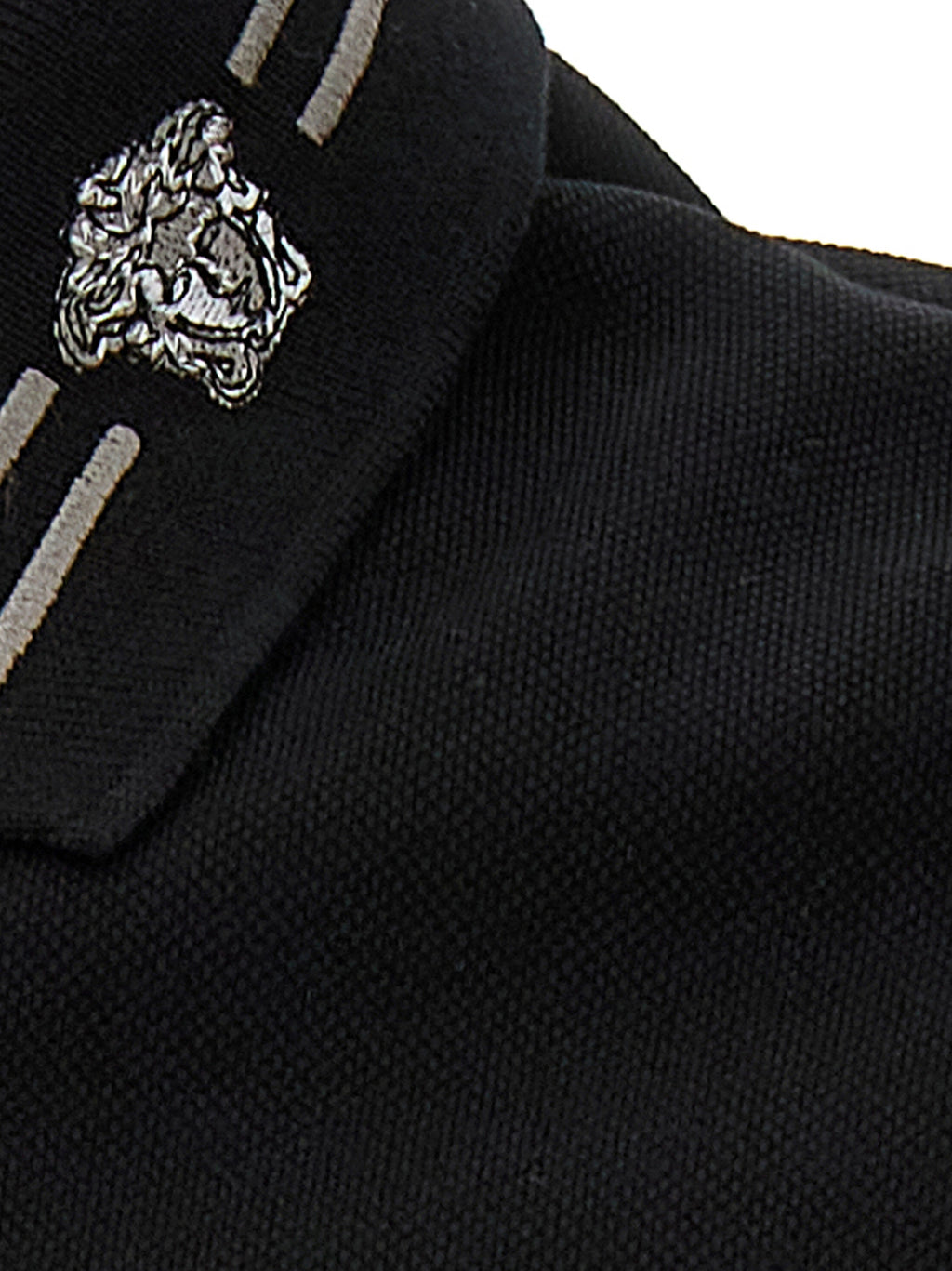 Chemise polo en coton noir de la marque Versace, avec logo distinctif visible sur la poitrine.
