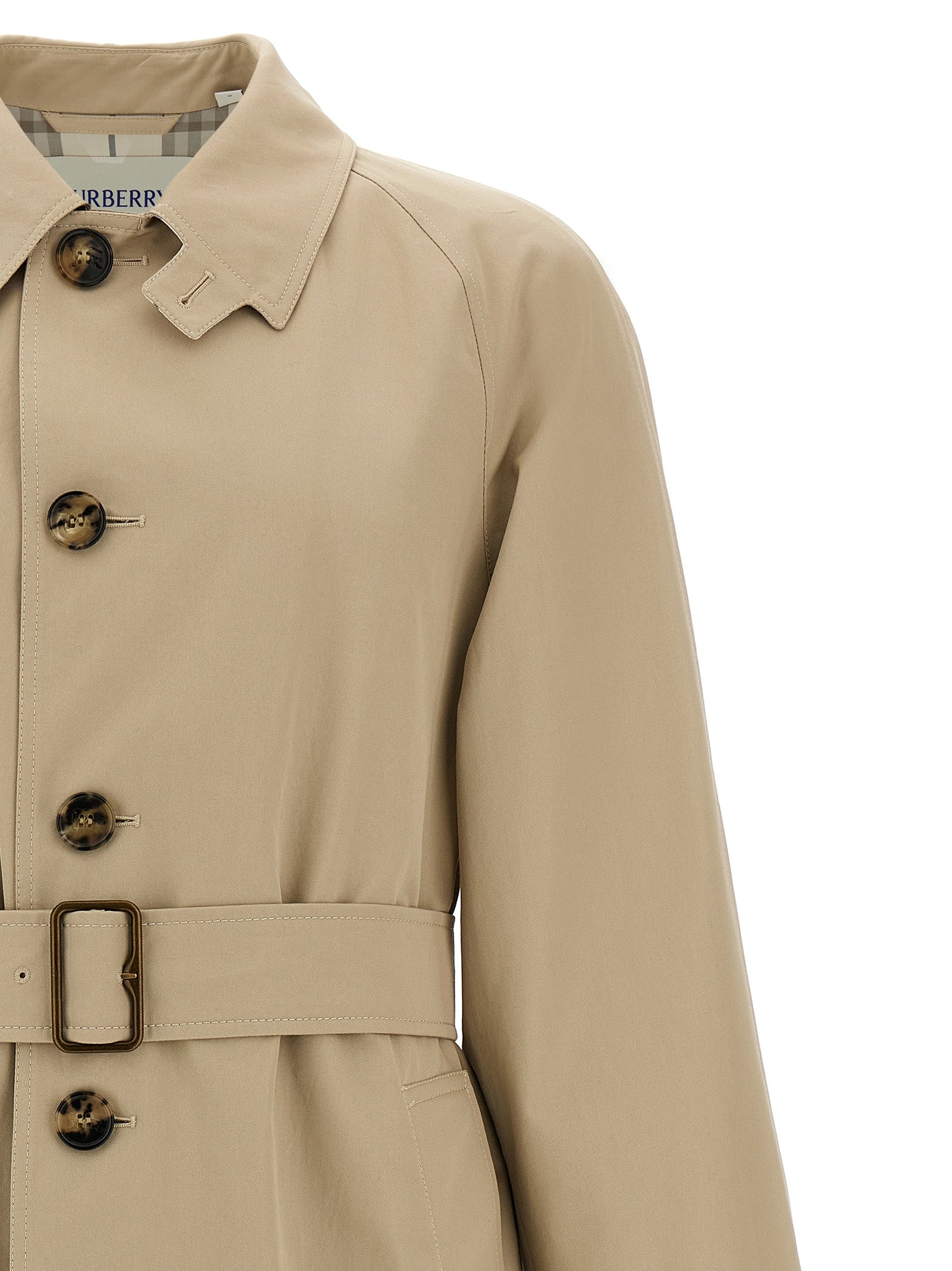 Manteau en coton beige de Burberry, coupe élégante, porté sur un mannequin, détails classiques et logo subtil.