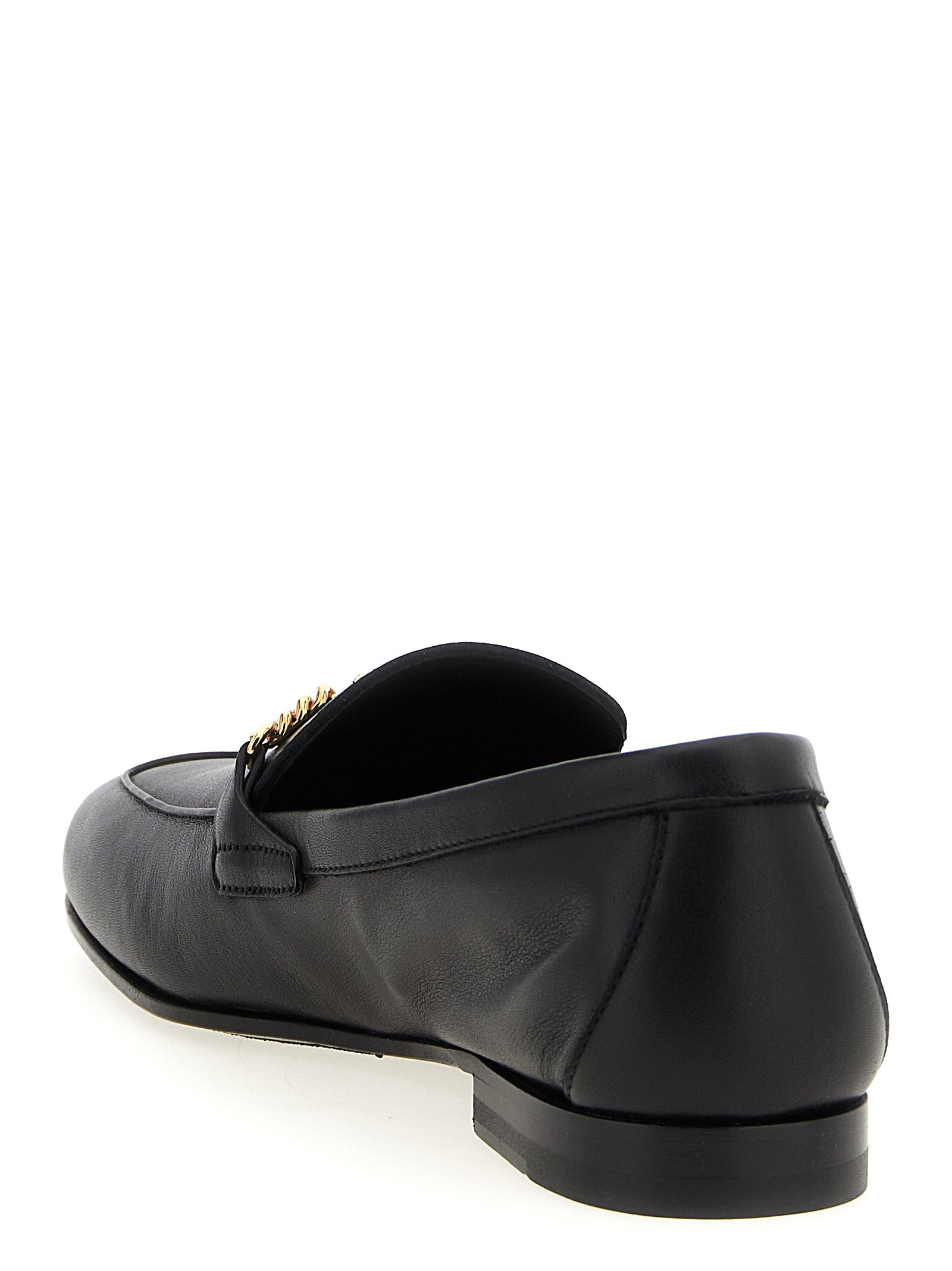 Chaussures mocassins slip-on en cuir de veau noir de la marque Versace, vue de côté avec détails élégants.