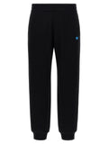 Pantalons de jogging en coton noir Versace pour la gym, avec logo distinctif et coupe décontractée, visible sur l'image.