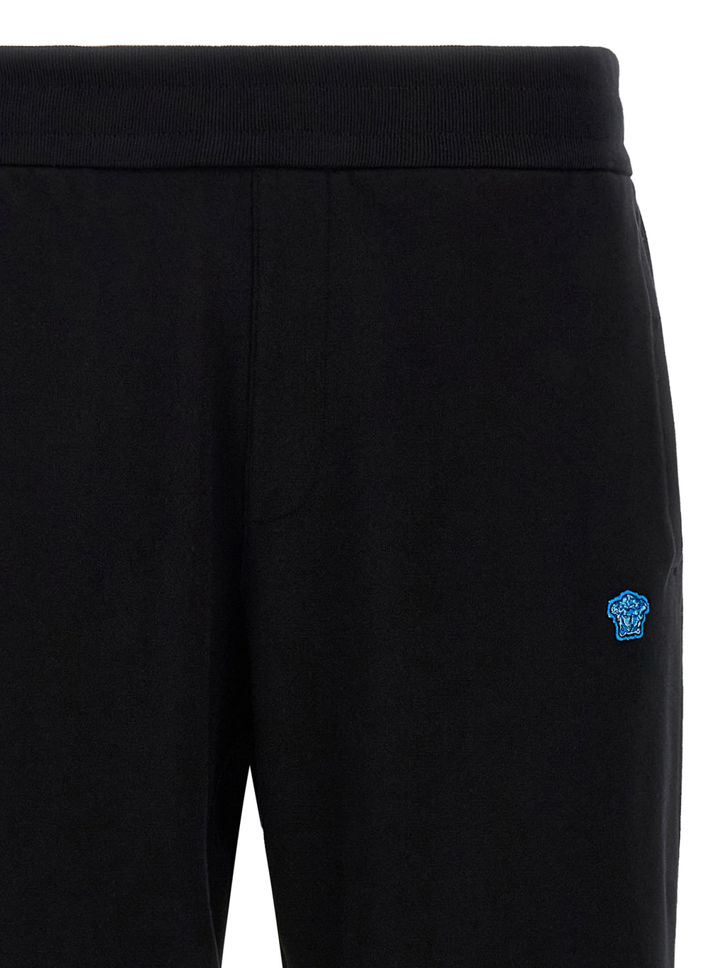 Pantalons de jogging en coton noir Versace pour l'entraînement, coupe décontractée, avec logo Versace visible sur la jambe.