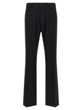 Pantalon en laine noir Balenciaga pour femme, coupe élégante et moderne, porté avec une chemise blanche.