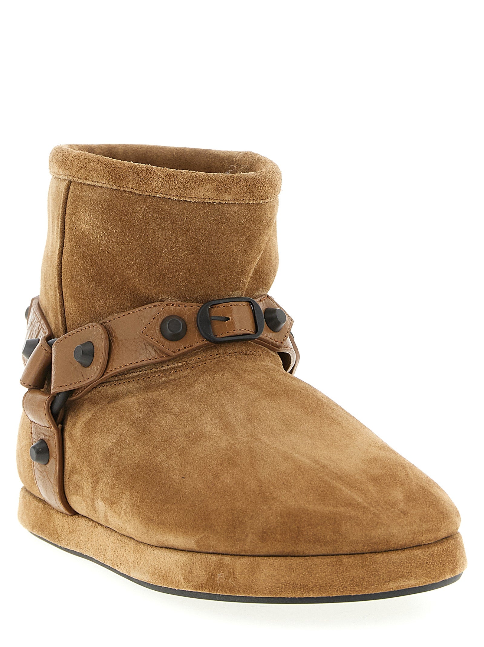 Bottes de cheville en cuir de veau beige Balenciaga, style élégant et moderne, visibles en détail dans l'image.