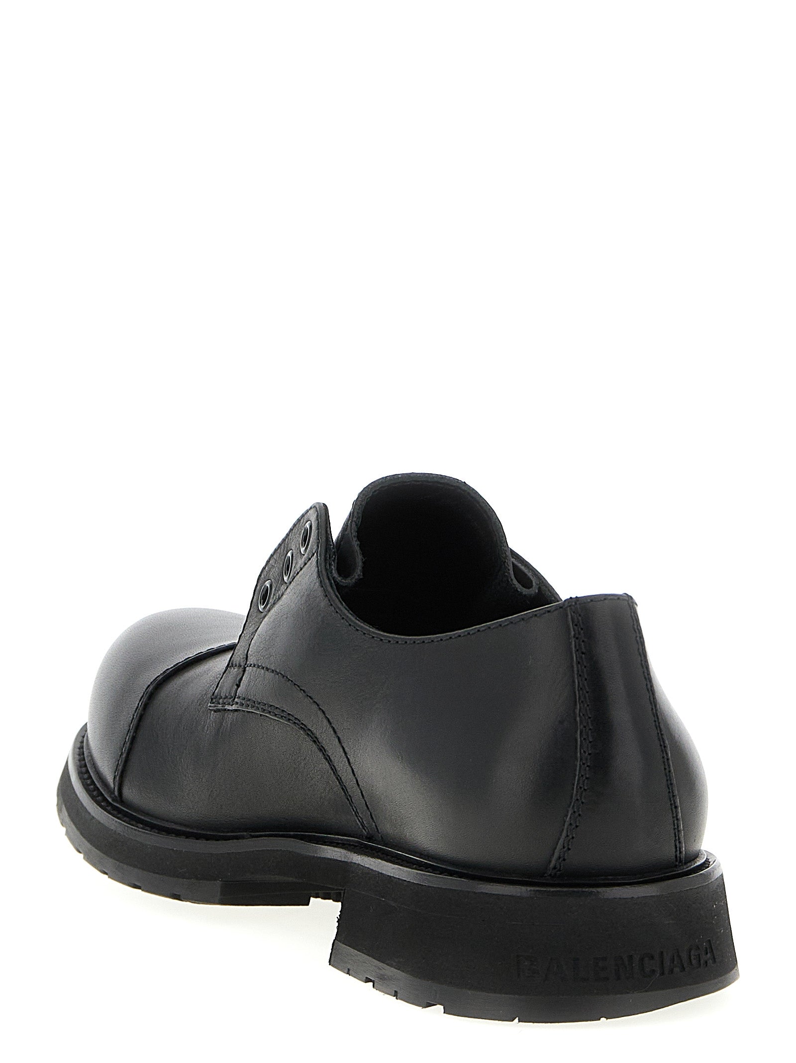 Chaussures slip-on Balenciaga en cuir de taureau noir, élégantes et modernes, avec finition soignée et design minimaliste.