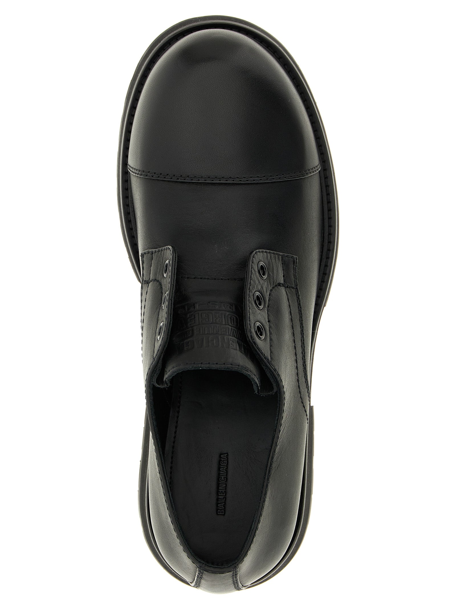Chaussures mocassins slip-on en peau de taureau noir de Balenciaga, élégantes et modernes, visibles en gros plan.