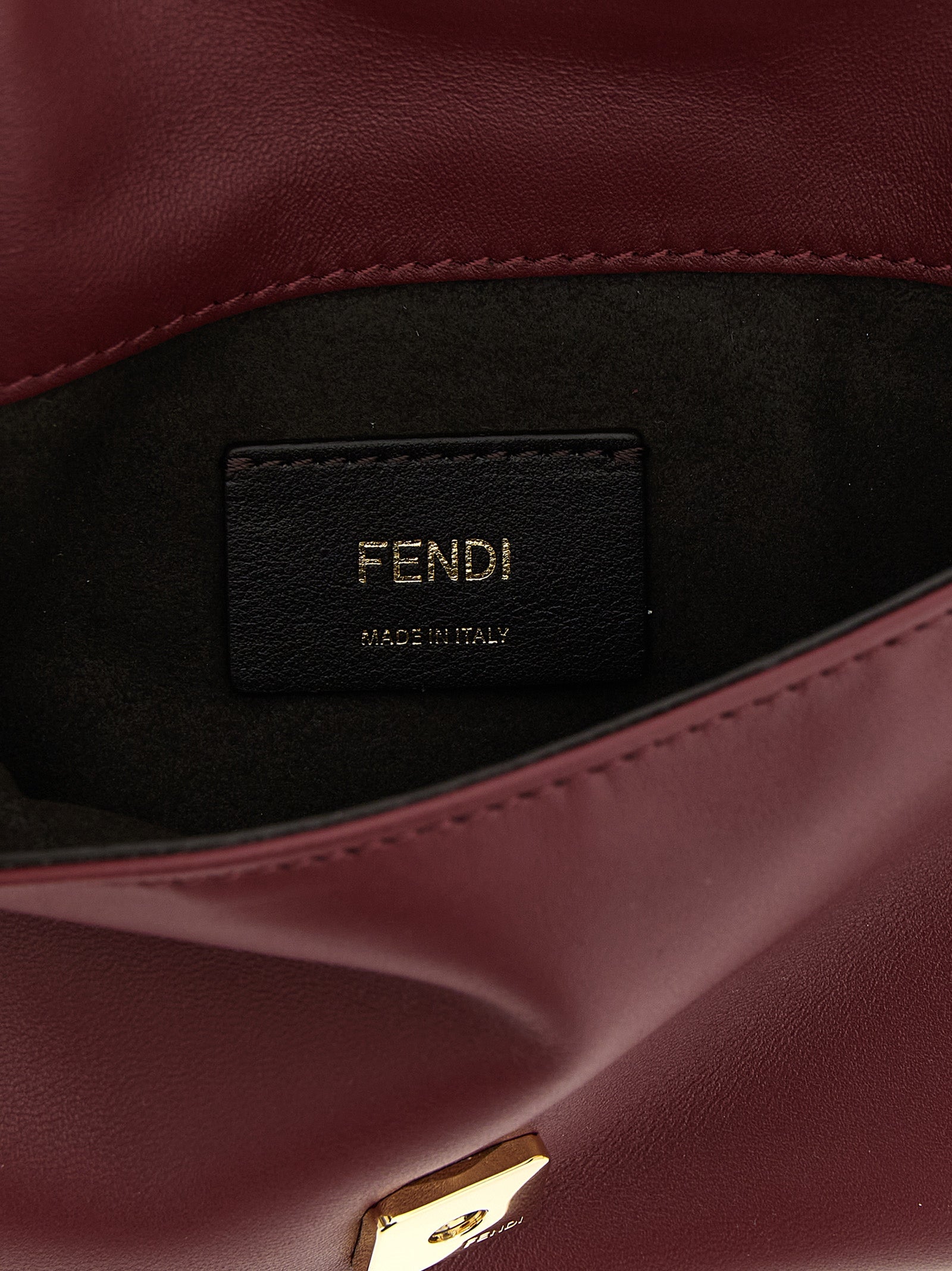 Sac clutch Fendi en cuir d'agneau bordeaux, élégant et sophistiqué, avec finition raffinée et design compact.