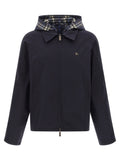 Veste longue en coton bleu de Burberry, style classique avec détails élégants, portée sur un mannequin.