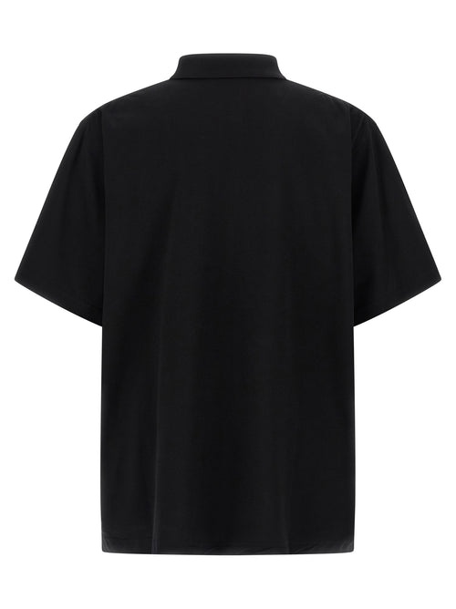 Chemise polo noire en coton de Balenciaga, vue de face, avec col classique et logo discret sur la poitrine.