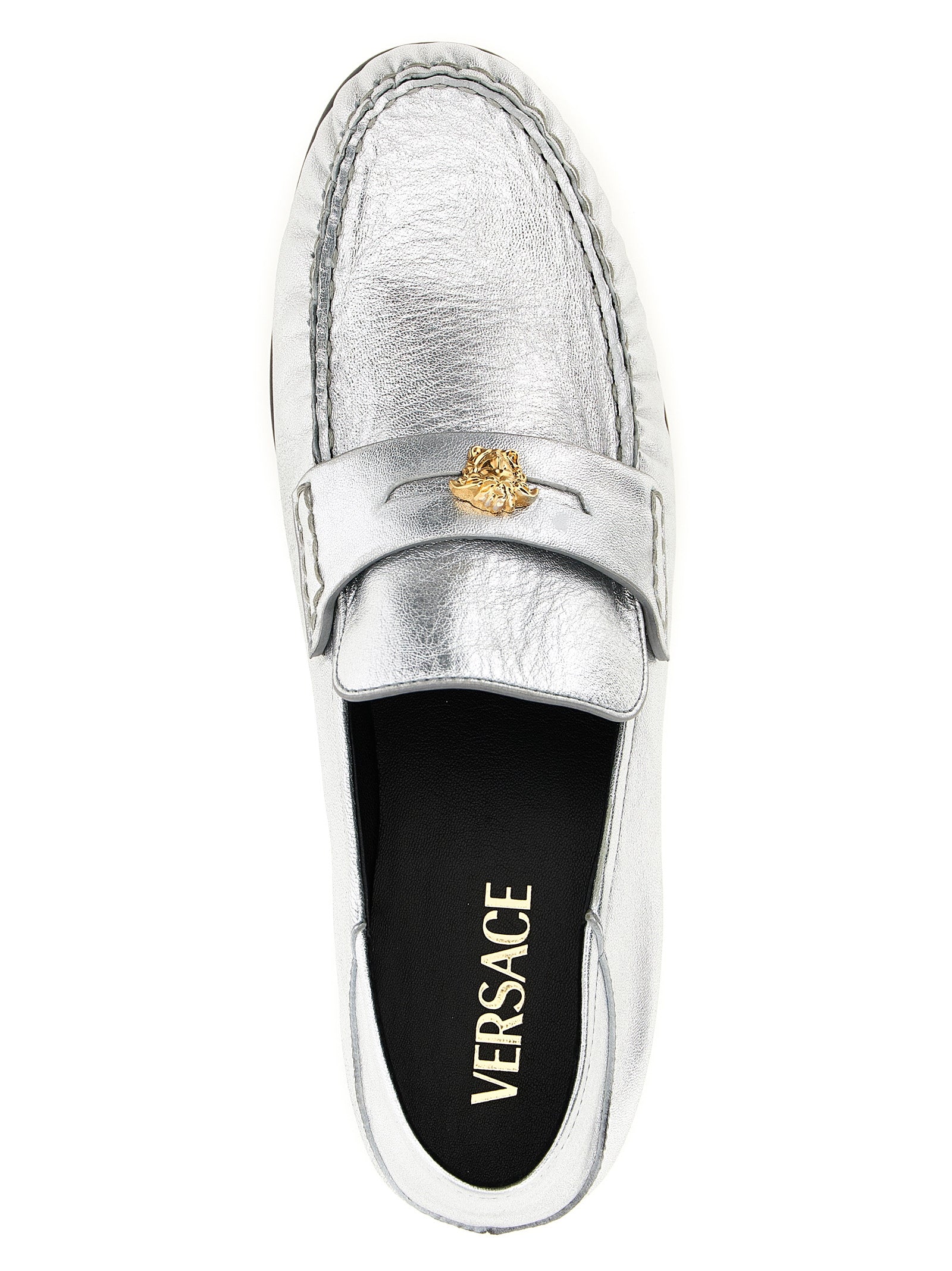 Mocassins slip-on en cuir d'agneau argenté de Versace, élégants et confortables, visibles sur cette image.