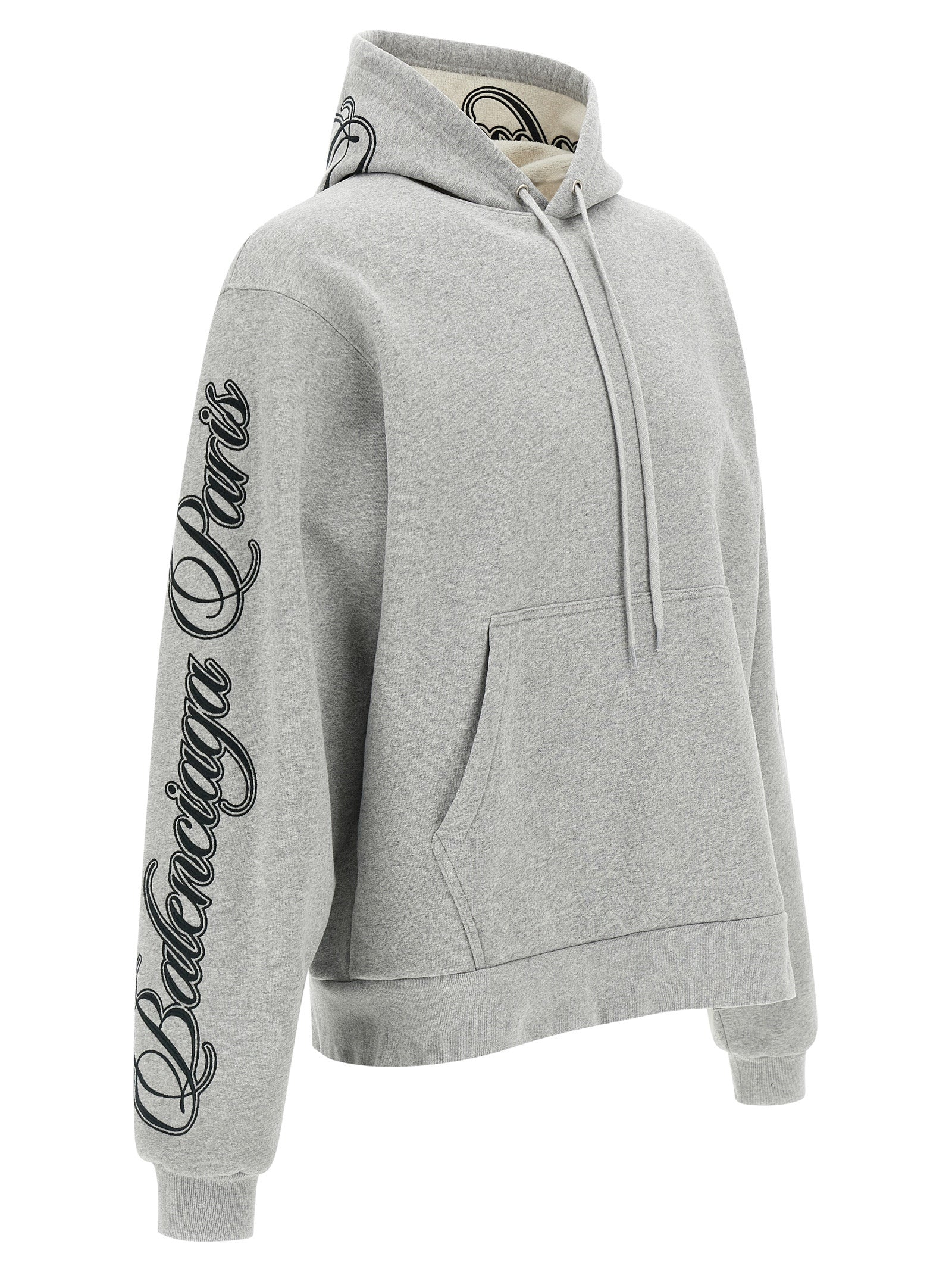 Sweat-shirt gris en coton de la marque Balenciaga, avec logo discret, porté dans une tenue décontractée.