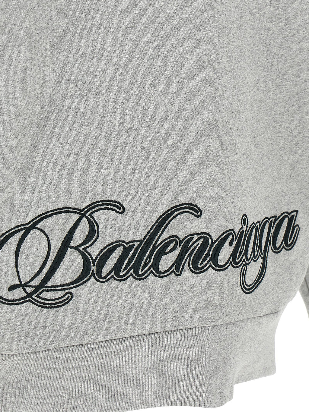 Sweat-shirt gris en coton de Balenciaga, coupe décontractée, avec logo discret sur la poitrine, porté en style casual.
