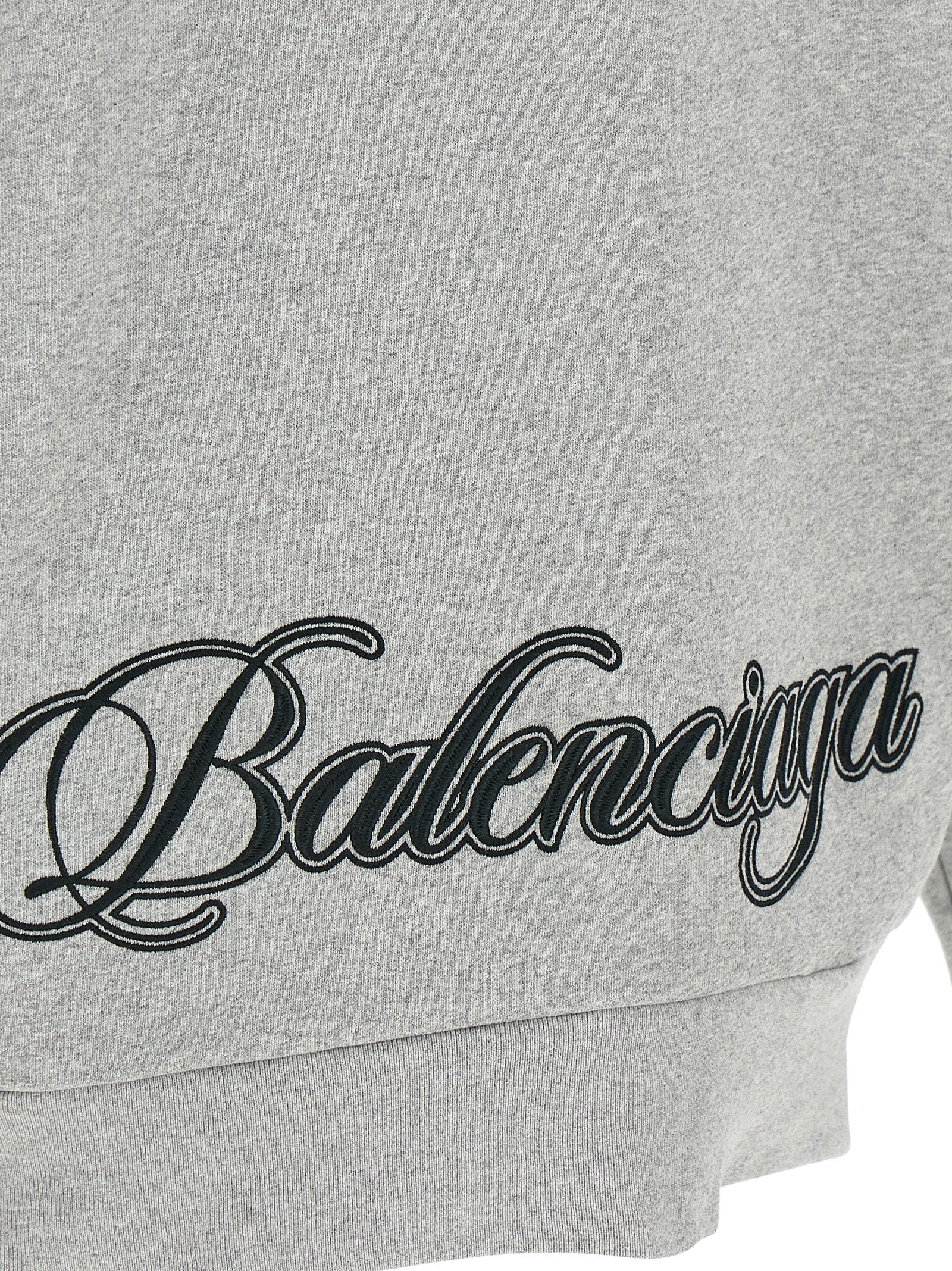 Sweat-shirt gris en coton de Balenciaga, coupe décontractée, avec logo discret sur la poitrine, porté en style casual.