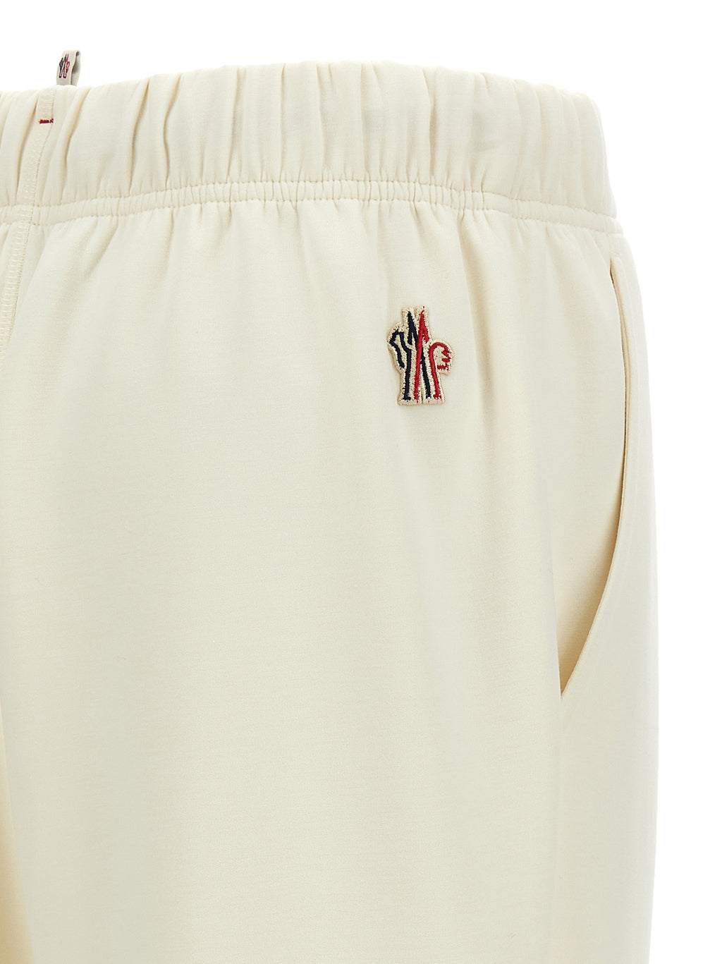 Pantalons de jogging en polyester blanc Moncler Grenoble pour entraînement, affichant une coupe décontractée et détails modernes.